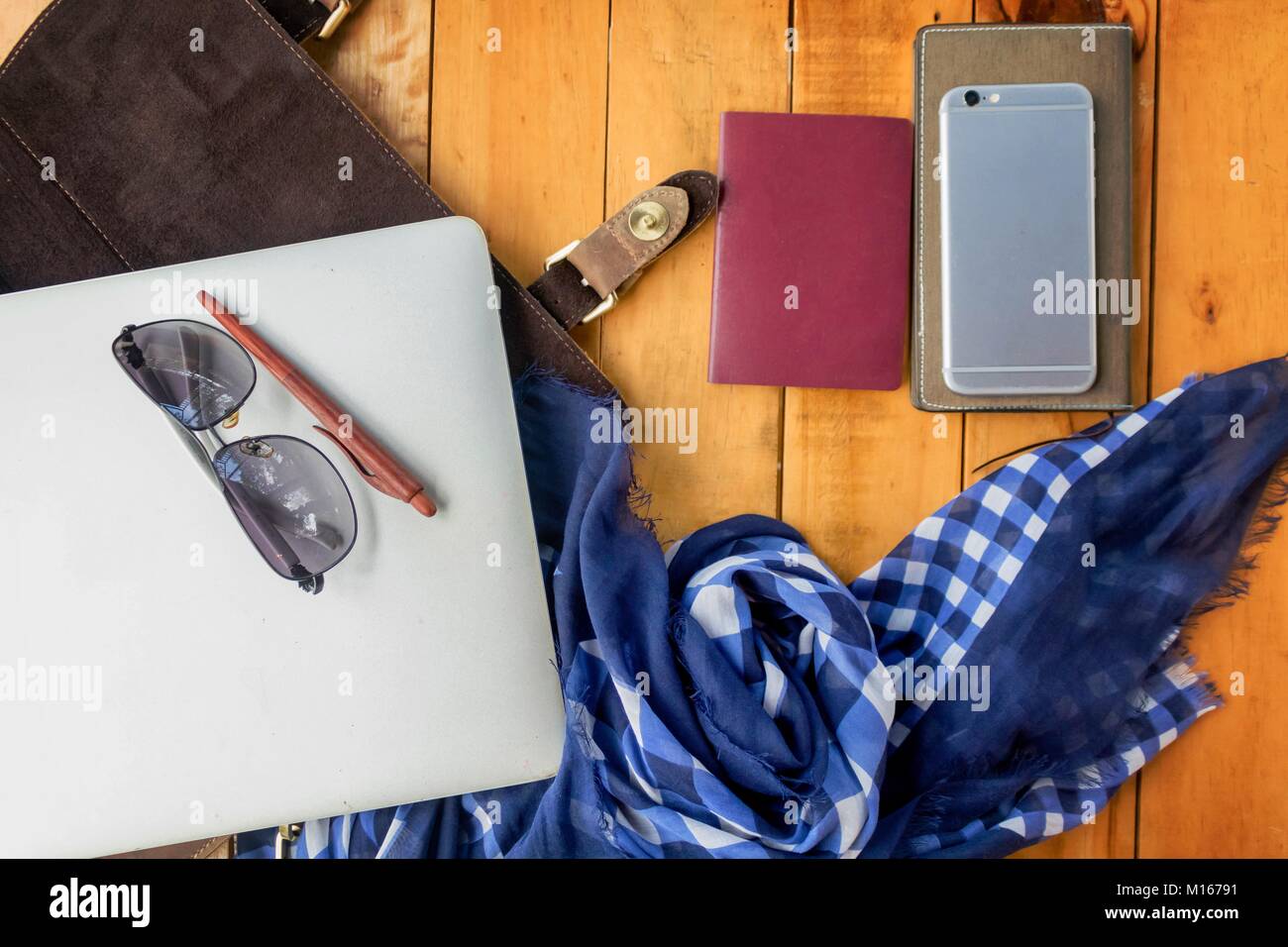 Occhiali da sole portatile Passport telefono cellulare e controllare la sciarpa sul tavolo di legno Foto Stock