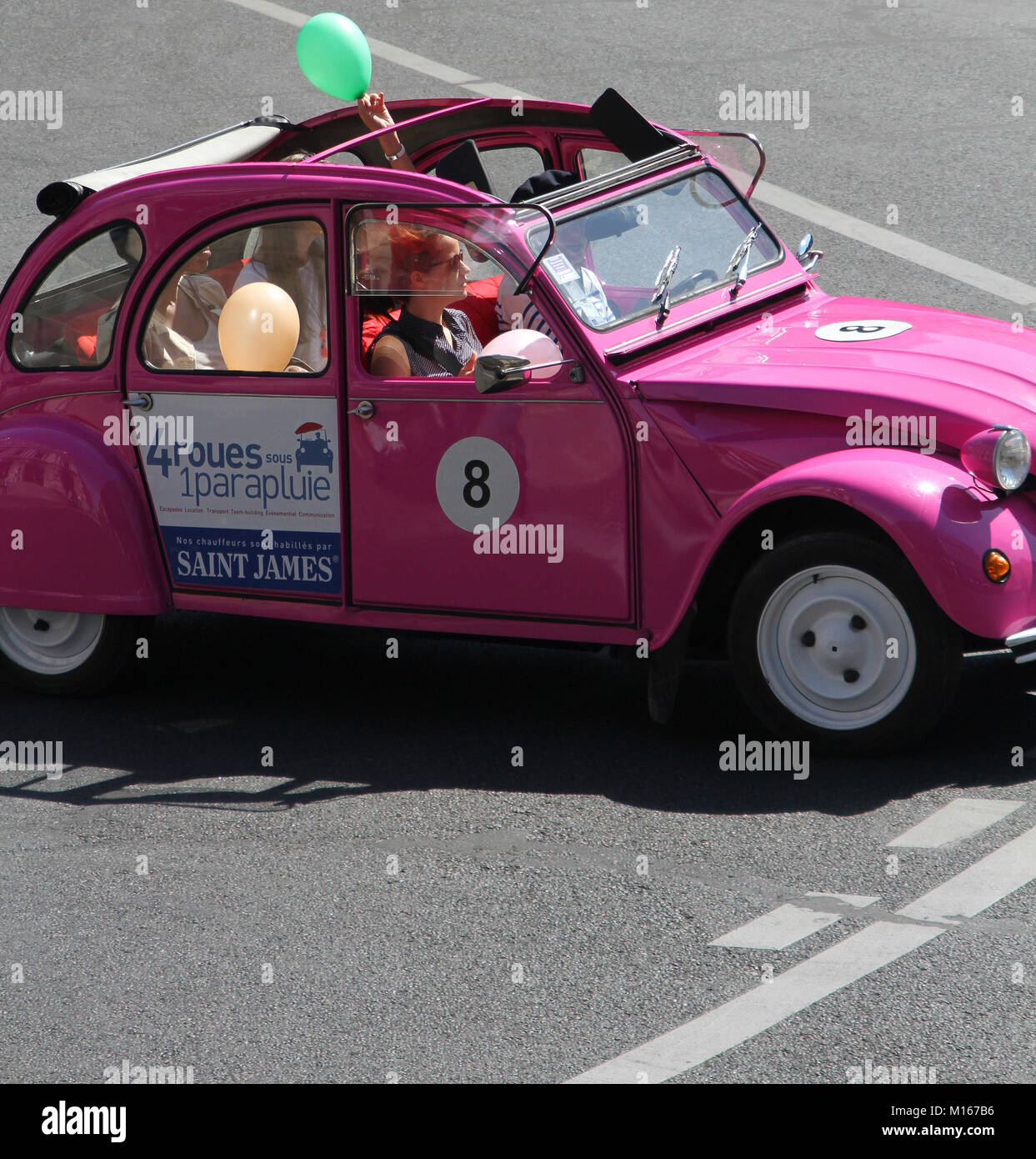 A 4 Roues sour 1 parapluie (4 ruote al di sotto di 1 ombrellone) Agenzia touring su di una vettura Citroën 2CV con passeggeri e conducente, touring intorno a Parigi, Francia. Foto Stock