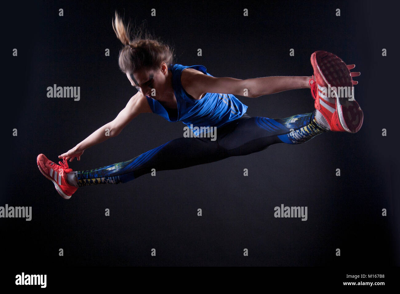 Atleta donna in posa su sfondo nero Foto Stock