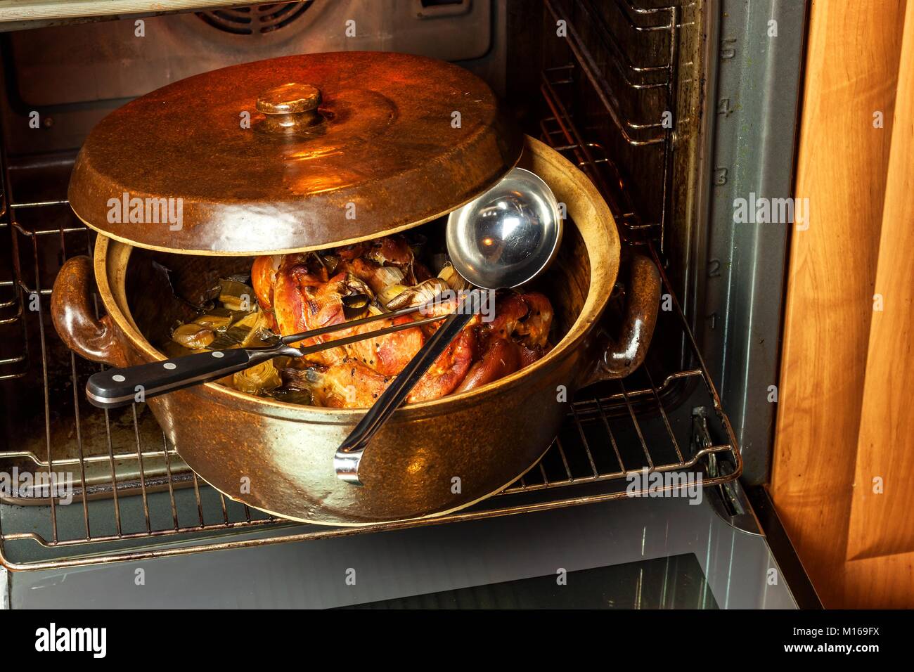 Arrosto di maiale ginocchio con il porro. La cottura della carne. Elettrodomestici Forno. Stoviglie Foto Stock