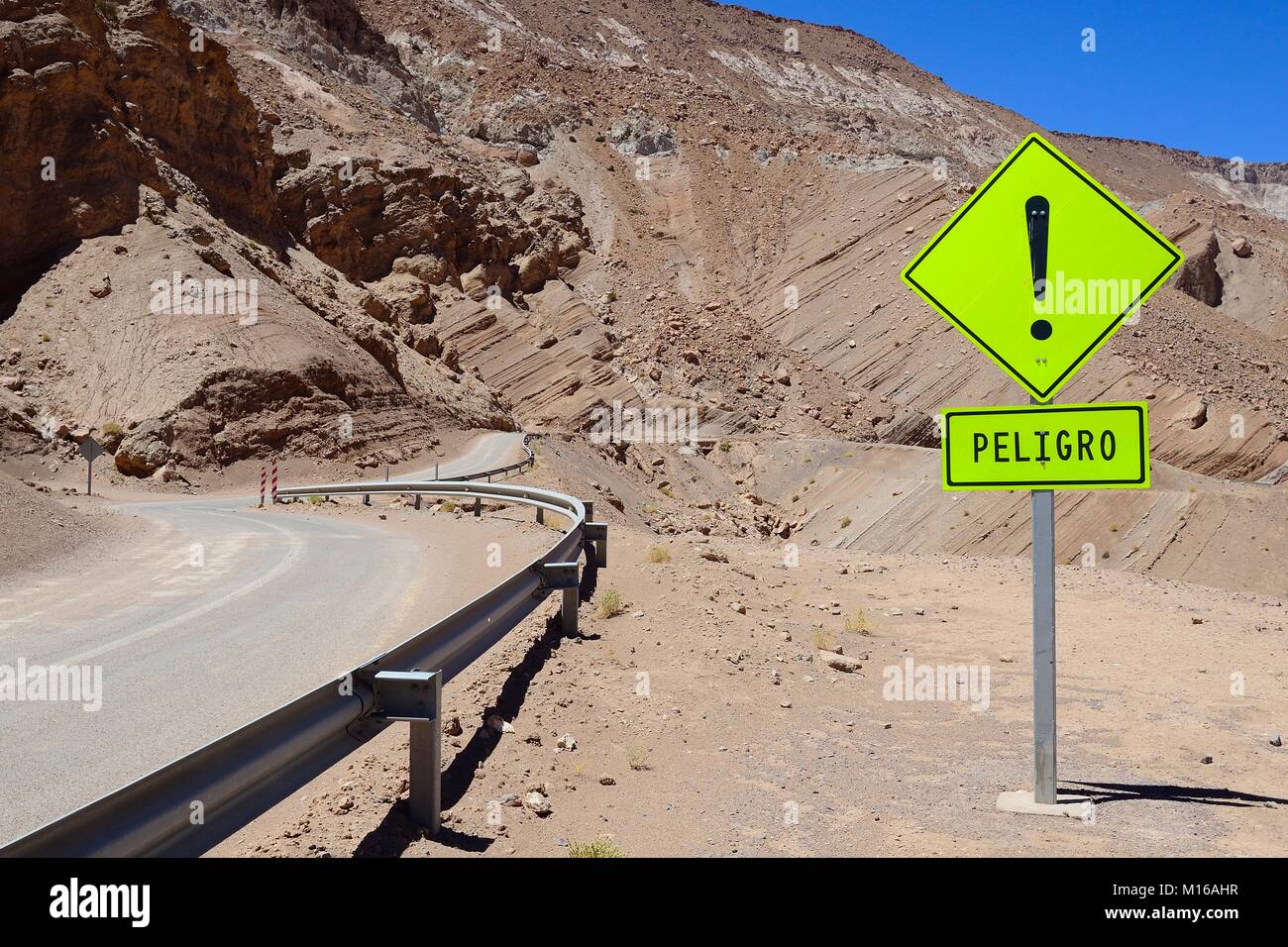Un segnale di avviso nella parte anteriore di una curva, vicino a San Pedro de Atacama, Región de Antofagasta, Cile Foto Stock