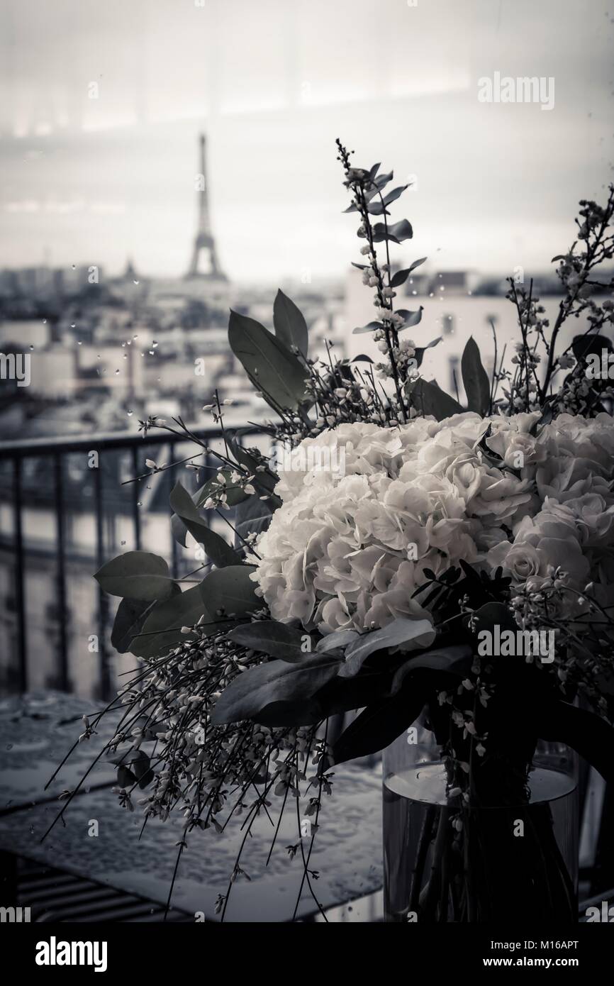 Close-up di un mazzo di fiori su di una terrazza o di un balcone con vista della città della Torre Eiffel nel centro cittadino di Parigi capitale della Francia Foto Stock