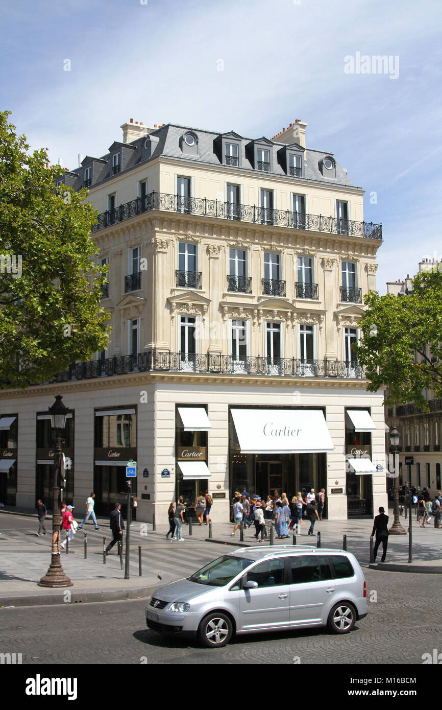 Un argento Volkswagen Touran guida nella parte anteriore di una boutique Cartier, l Avenue des Champs Elysees di Parigi, Francia. Foto Stock