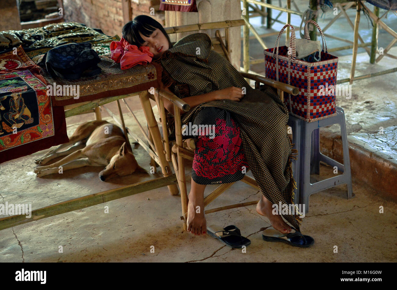 Un Burmese bambina si addormenta proteggendo allo stesso tempo la sua mercanzia durante la giornata calda. Foto Stock
