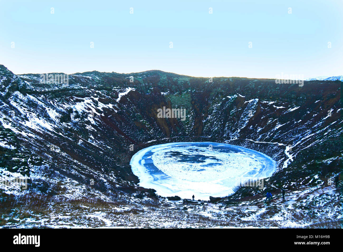 Kerið è un cratere vulcanico lago in Grímsnes nel sud dell'Islanda. Si tratta di una popolare stop quando si viaggia il Golden Circle. Si è creduto che Kerið era originariamente un cono vulcanico che ha eruttato e e svuotato la sua riserva di magma. Una volta che il magma era esaurita, il peso del cono è crollato in un vuoto della camera di magma, più tardi per essere riempito con acqua. La caldera Kerið è composta di rosso la roccia vulcanica ed è intorno a 55 m di profondità, 170 m e largo 270 m. Vi è poca vegetazione nella ripida parete del cratere, salva per una parete con una pendenza più dolce che è coperto con profonda moss. Kerio - Islanda Foto Stock
