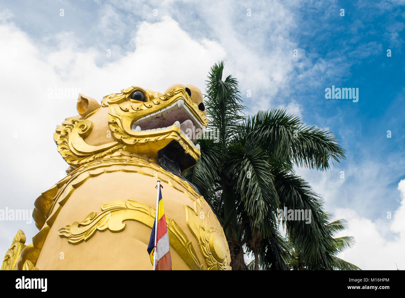 Un giallo chinthe statua, leogryph lion-come dragon, in piedi di fronte a un Nga Htat Gyi Pagoda, proteggendolo e gaurding. Yangon, MYANMAR Birmania Foto Stock