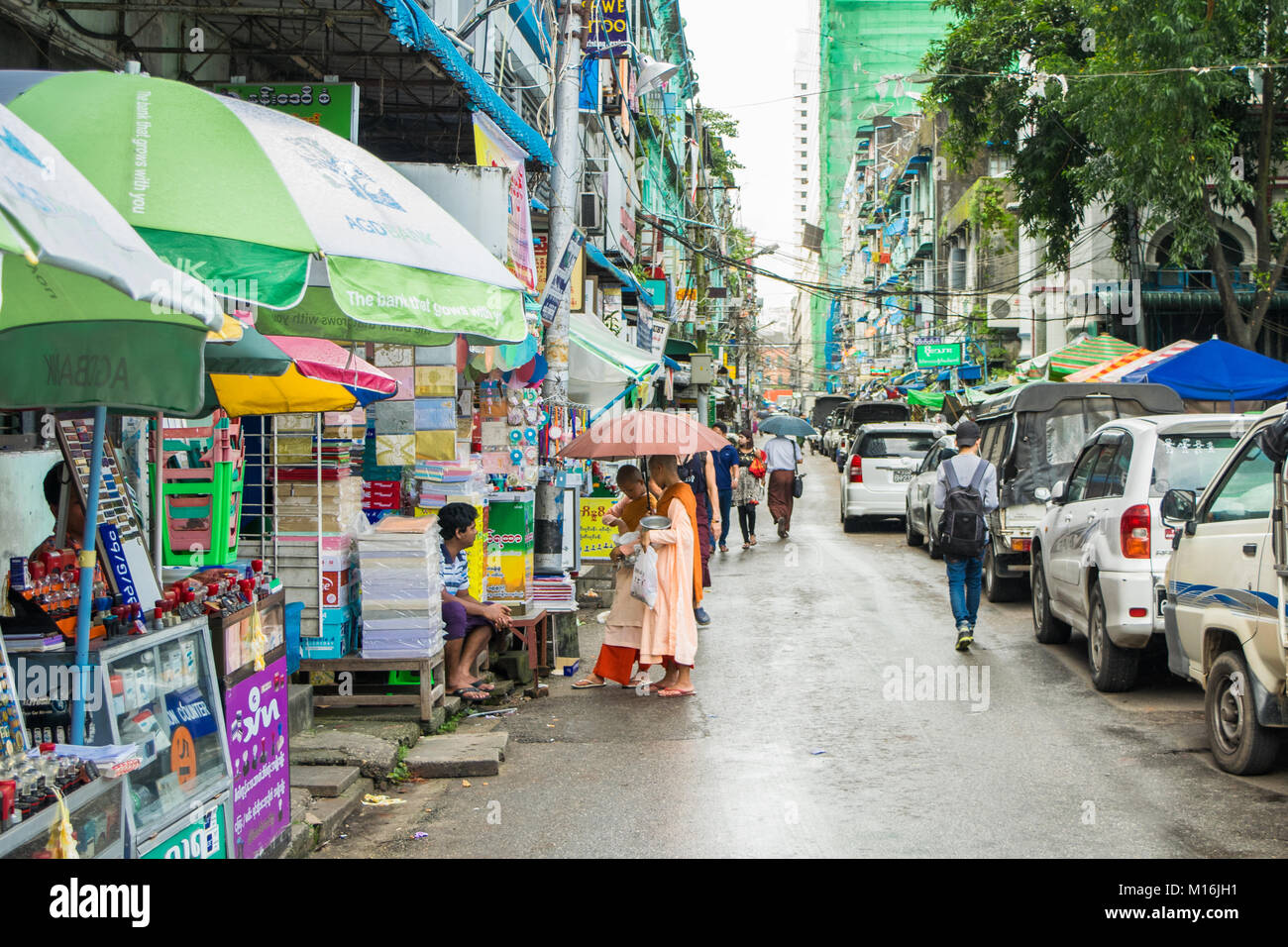 Due boy novizio monaci, coppia di bambini monaci, indossare vesti rosa, passeggiate in Yangon street quotidianamente la raccolta di elemosine e donazioni. La birmania, myanmar Asia SE Foto Stock