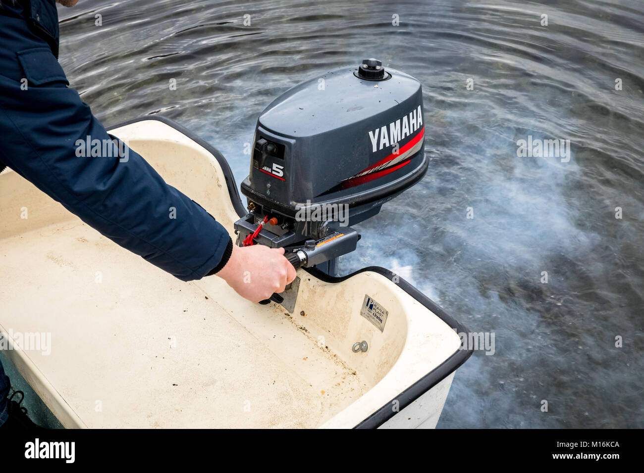 Haugesund, Norvegia - gennaio 10, 2018: l'uomo a partire una Yamaha motore  fuoribordo su una barca di plastica, fumo di scarico dal motore Foto stock  - Alamy