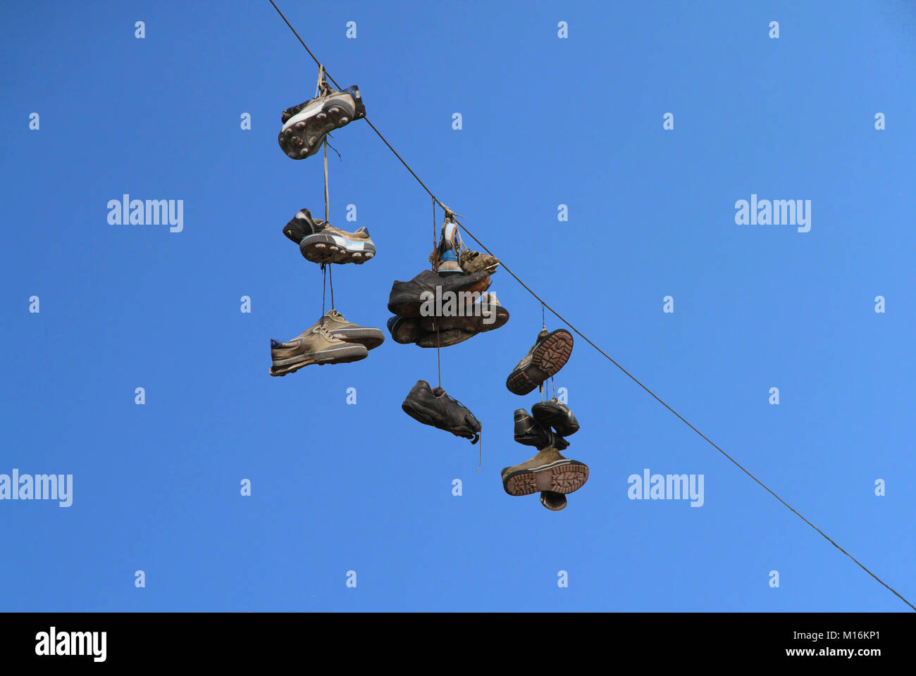 Stivali vecchi appendere su un cavo di alimentazione Foto Stock