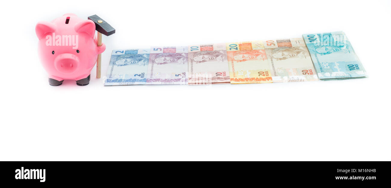 Il risparmio sui costi / brasiliano denaro e salvadanaio in uno sfondo bianco Foto Stock