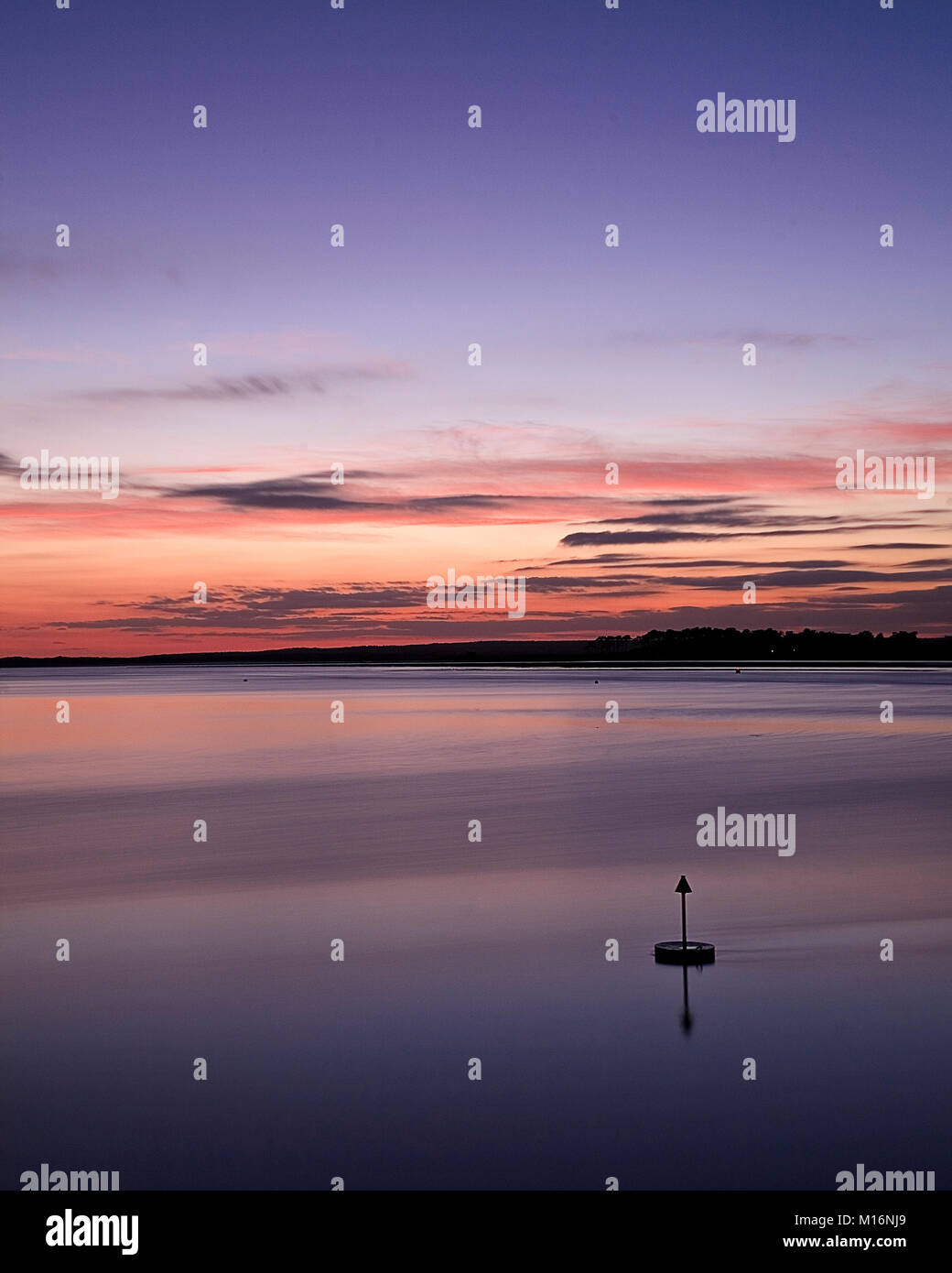 Bouy nel mare al tramonto a Caernarfon sulla costa gallese Foto Stock