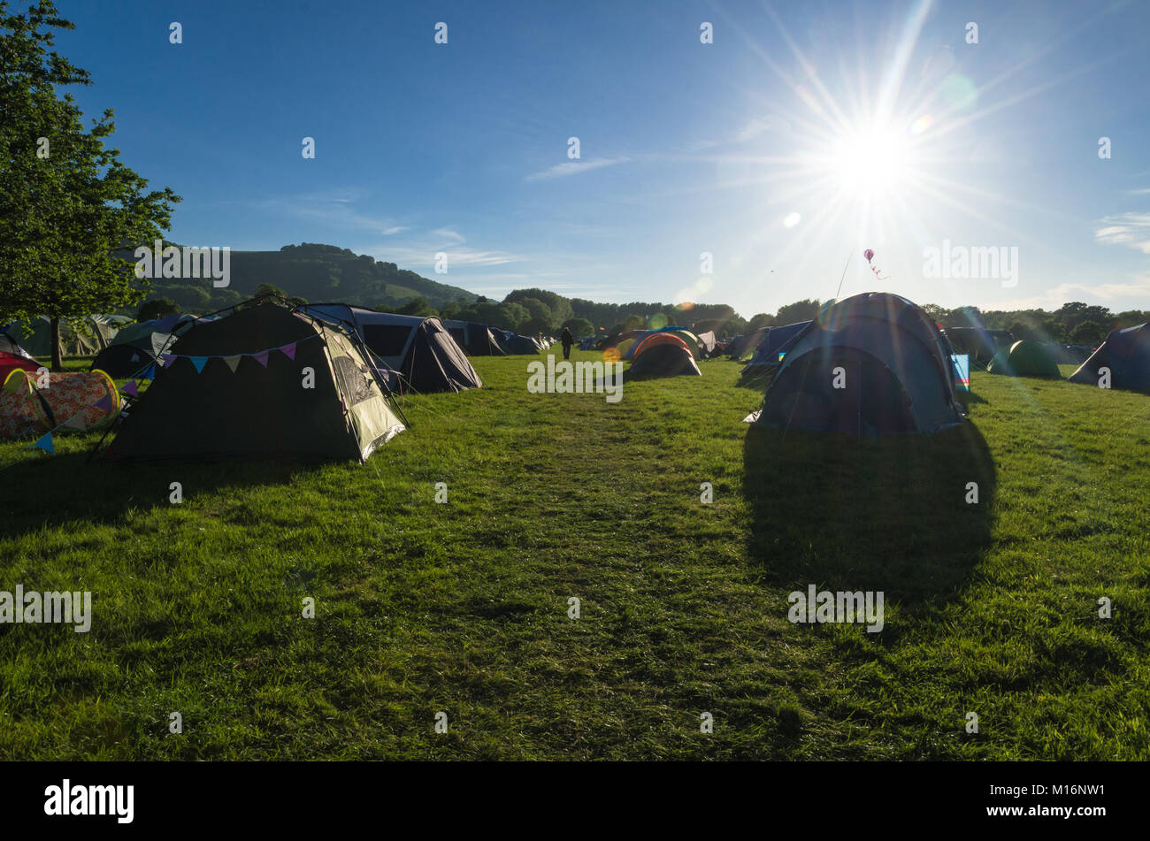 Silhouette di tende da campeggio a un campo estivo in campagna Foto Stock
