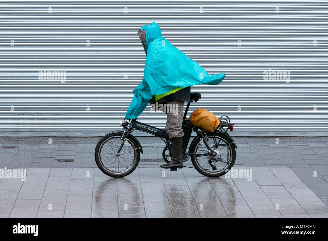 Un ciclista wet weather Pioggia Pioggia di colata di ciclo impermeabile cycling bike bike shelter tempesta acquazzone gli acquazzoni inverno freddo invernale ammollo soak Foto Stock