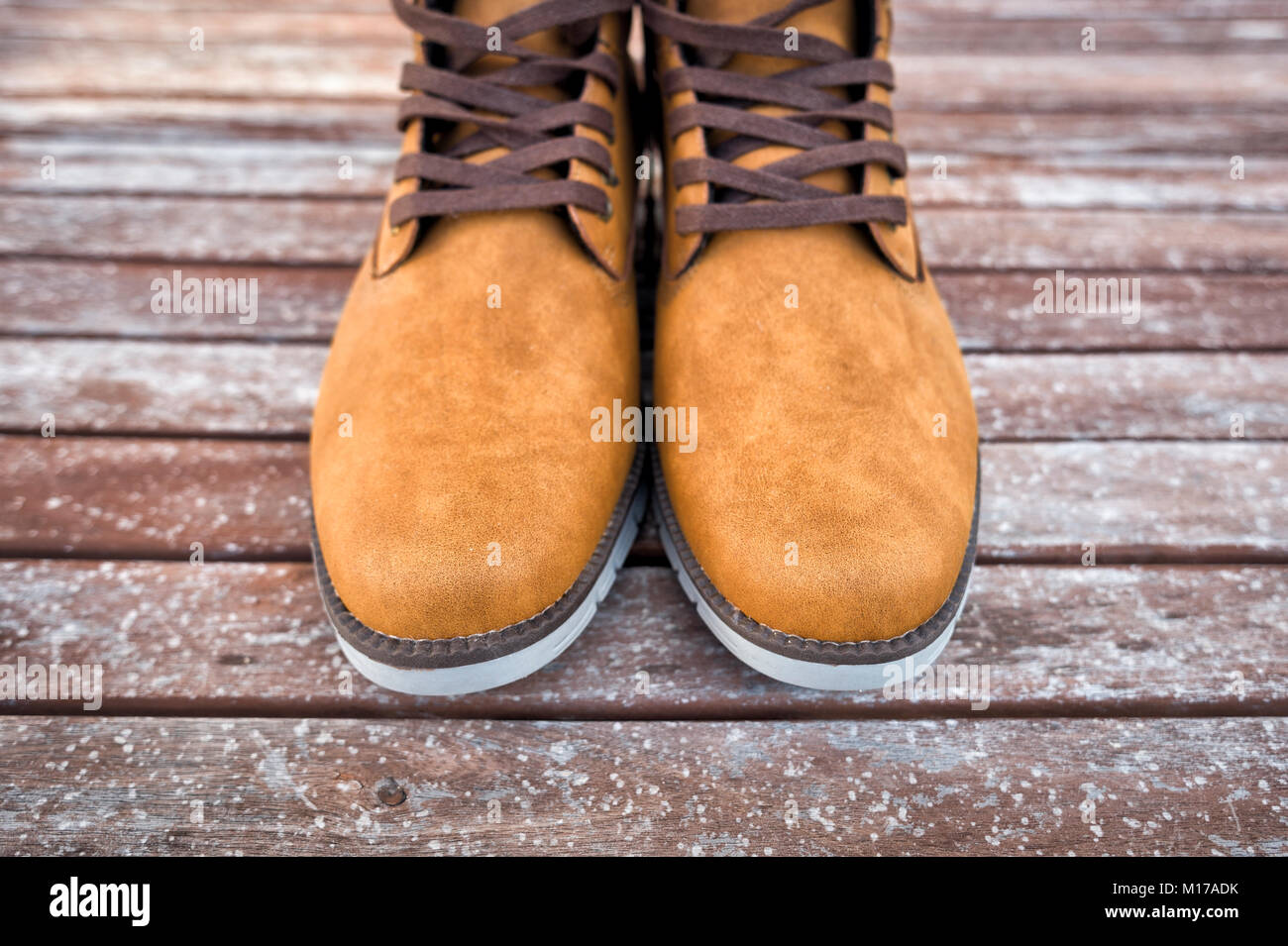 Coppia di mens tan stivali in pelle scamosciata su un pavimento di legno. Foto Stock