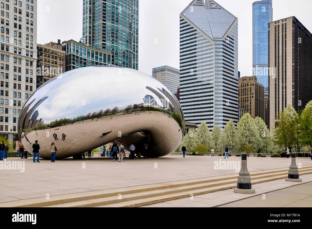 Chicago, IL - 5 Maggio 2011 - Il Cloud Gate (Il Bean) scultura in Millennium Park con turisti e vista di Chicago's architettura in un nuvoloso giorno di primavera Foto Stock