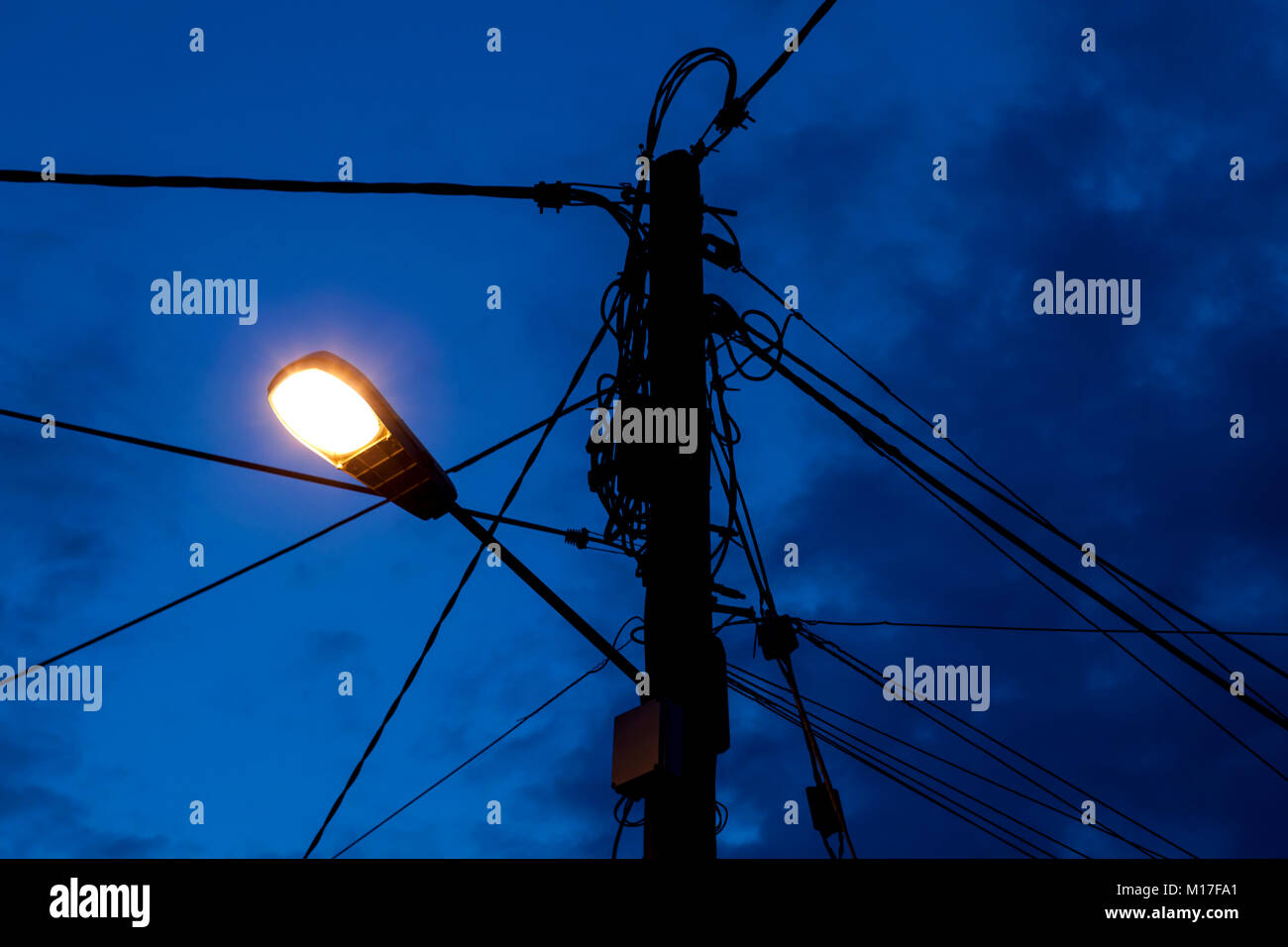 Rurale di overhead linee elettriche e linee telefoniche su un palo in un villaggio rurale in U.K. Foto Stock