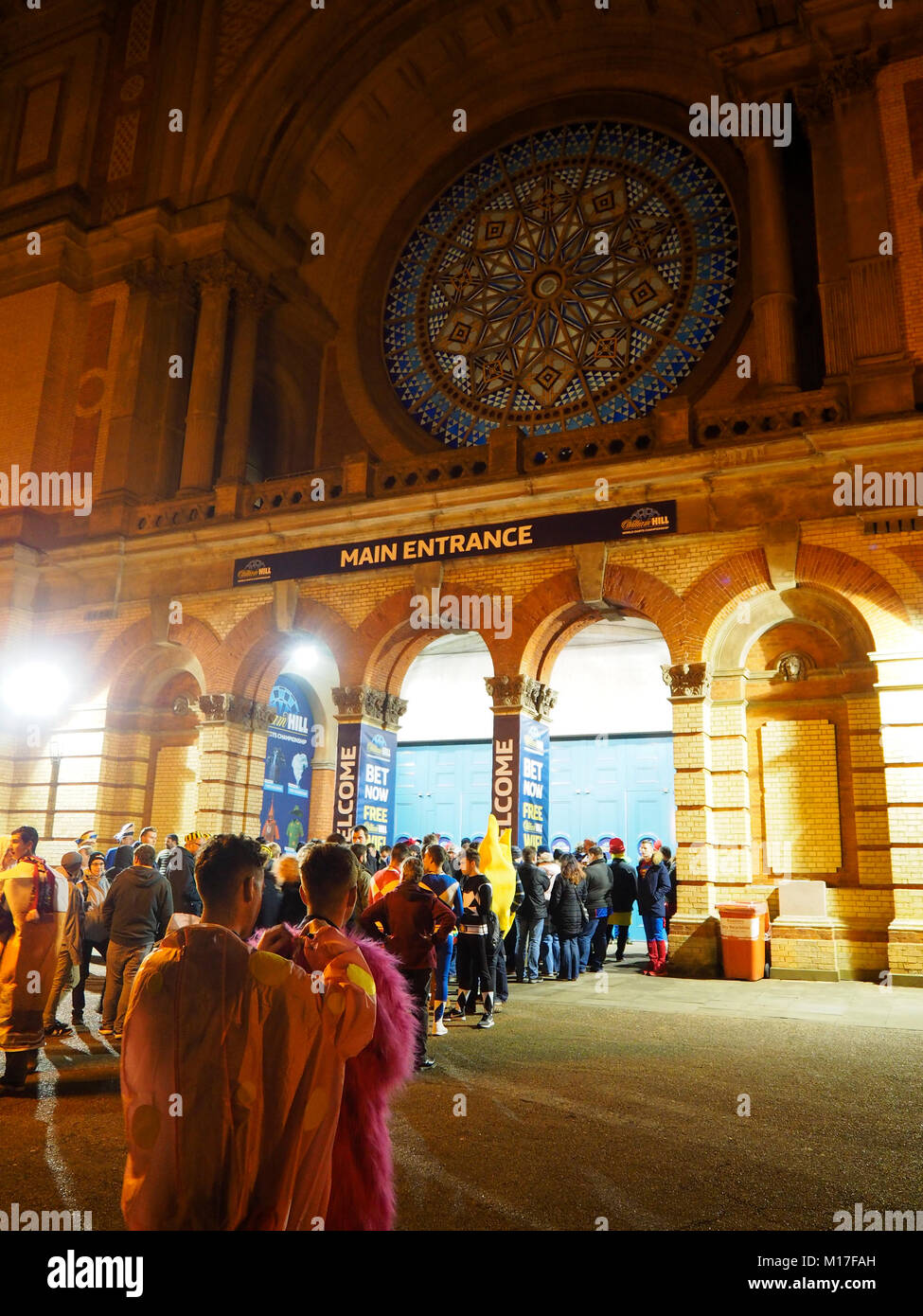 London, Regno Unito - 30 DIC 2017: Dart di ventole in abiti a fantasia sono in coda al di fuori della Londra Alexandra Palace (Ally Pally) per guardare le freccette campionato. Foto Stock