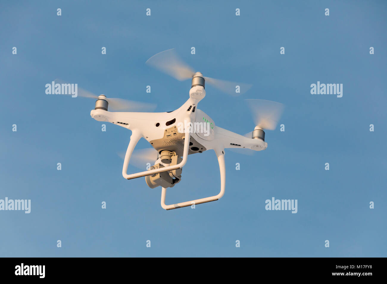 Flying drone bianco Phantom sul cielo blu. Sbarco di un droned mano con eliche di filatura Foto Stock