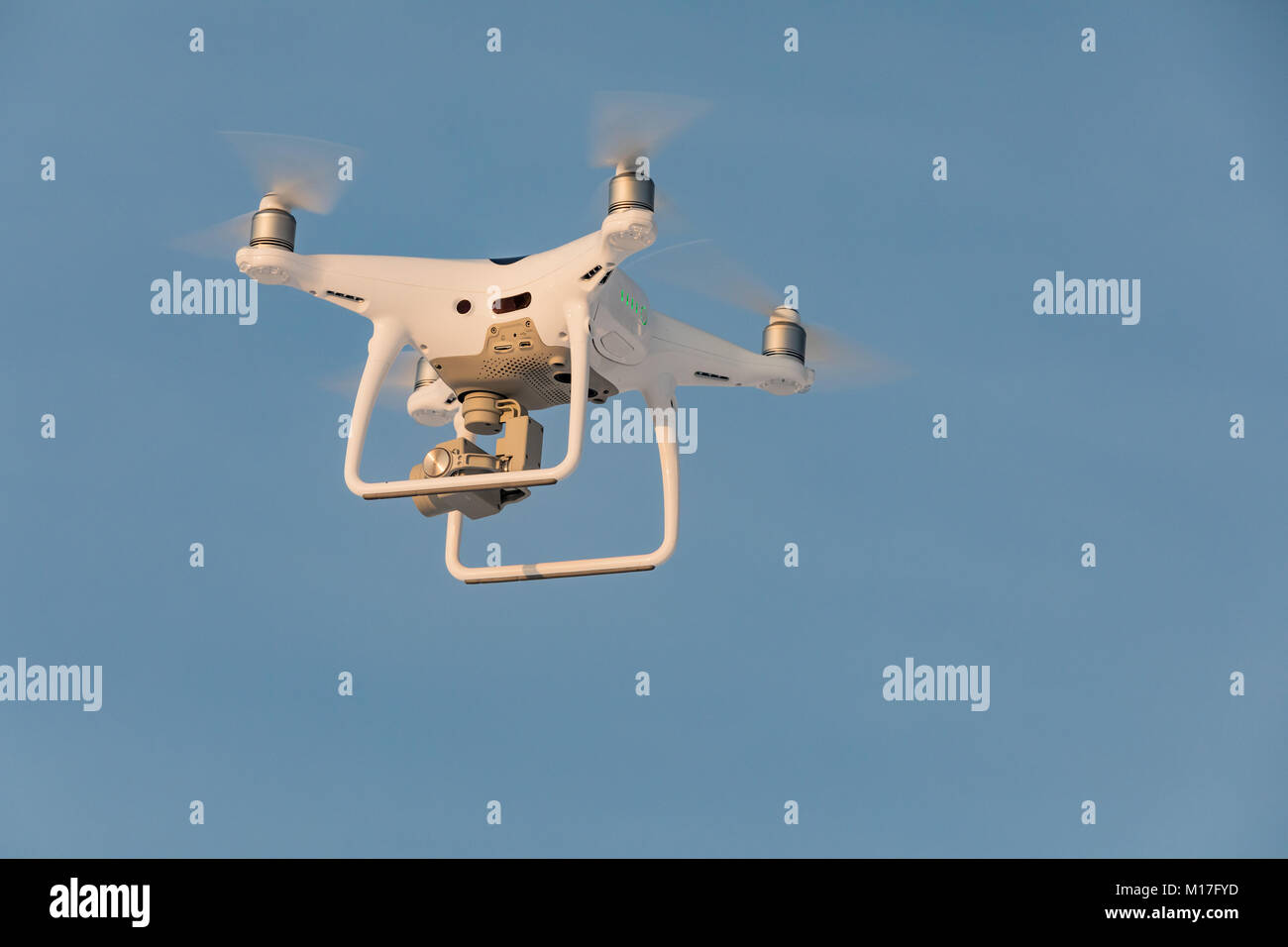 Flying drone bianco Phantom sul cielo blu. Sbarco di un droned mano con eliche di filatura Foto Stock