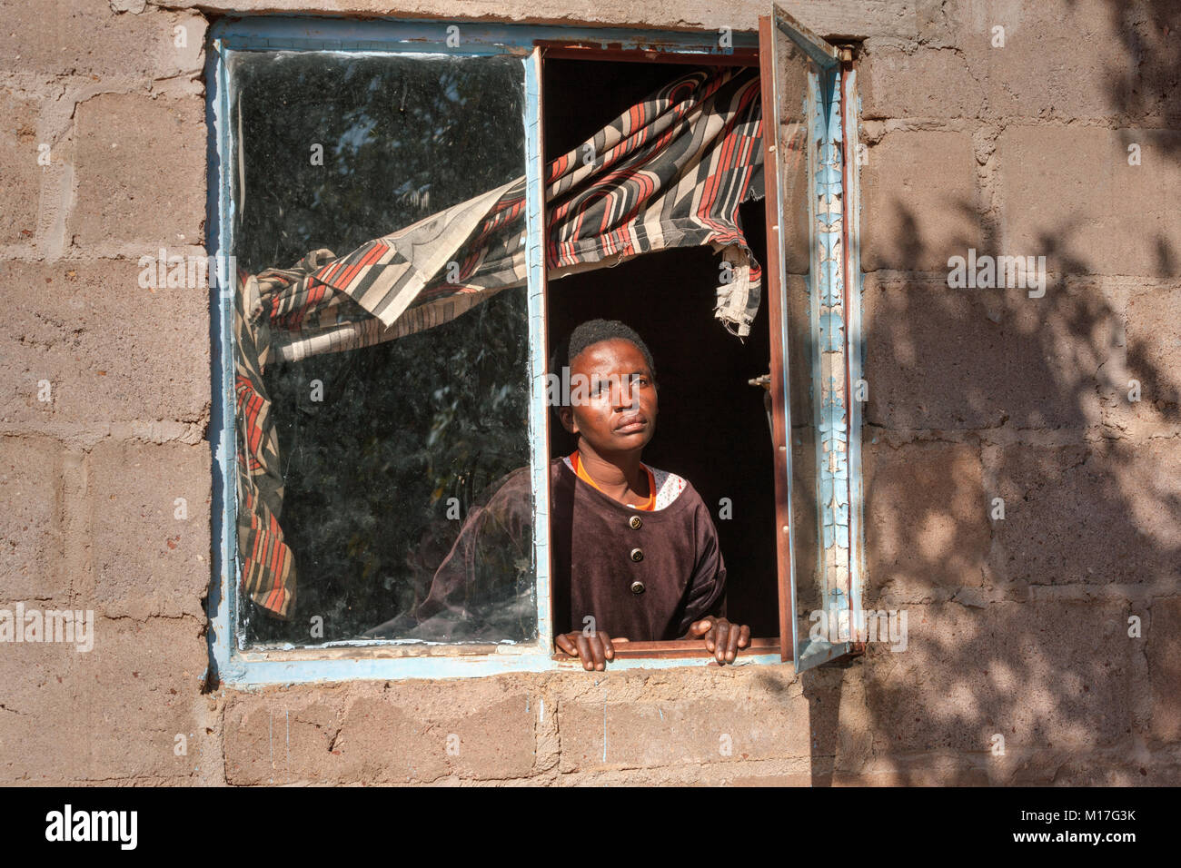 Donna africana nella finestra nel villaggio, Botswana Foto Stock