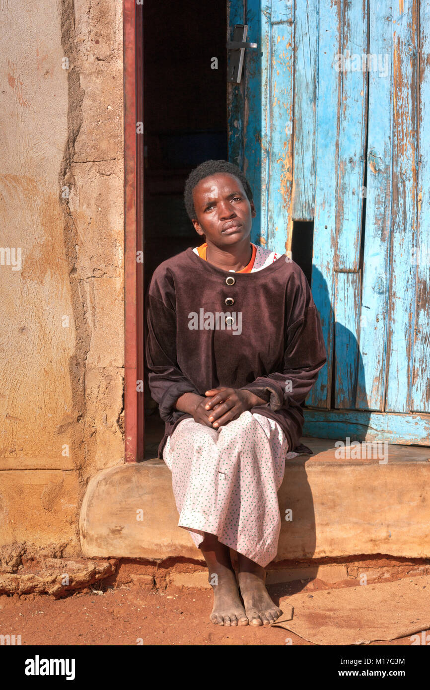 Donna africana di fronte alla casa di villaggio, Botswana Foto Stock