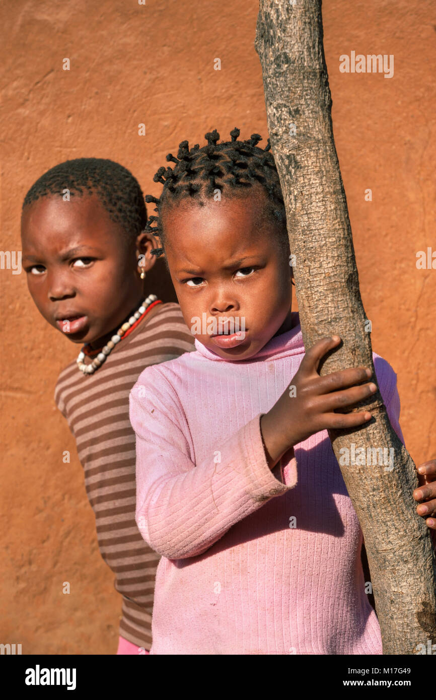 Fratelli africani nel retro della casa di villaggio, Botswana Foto Stock