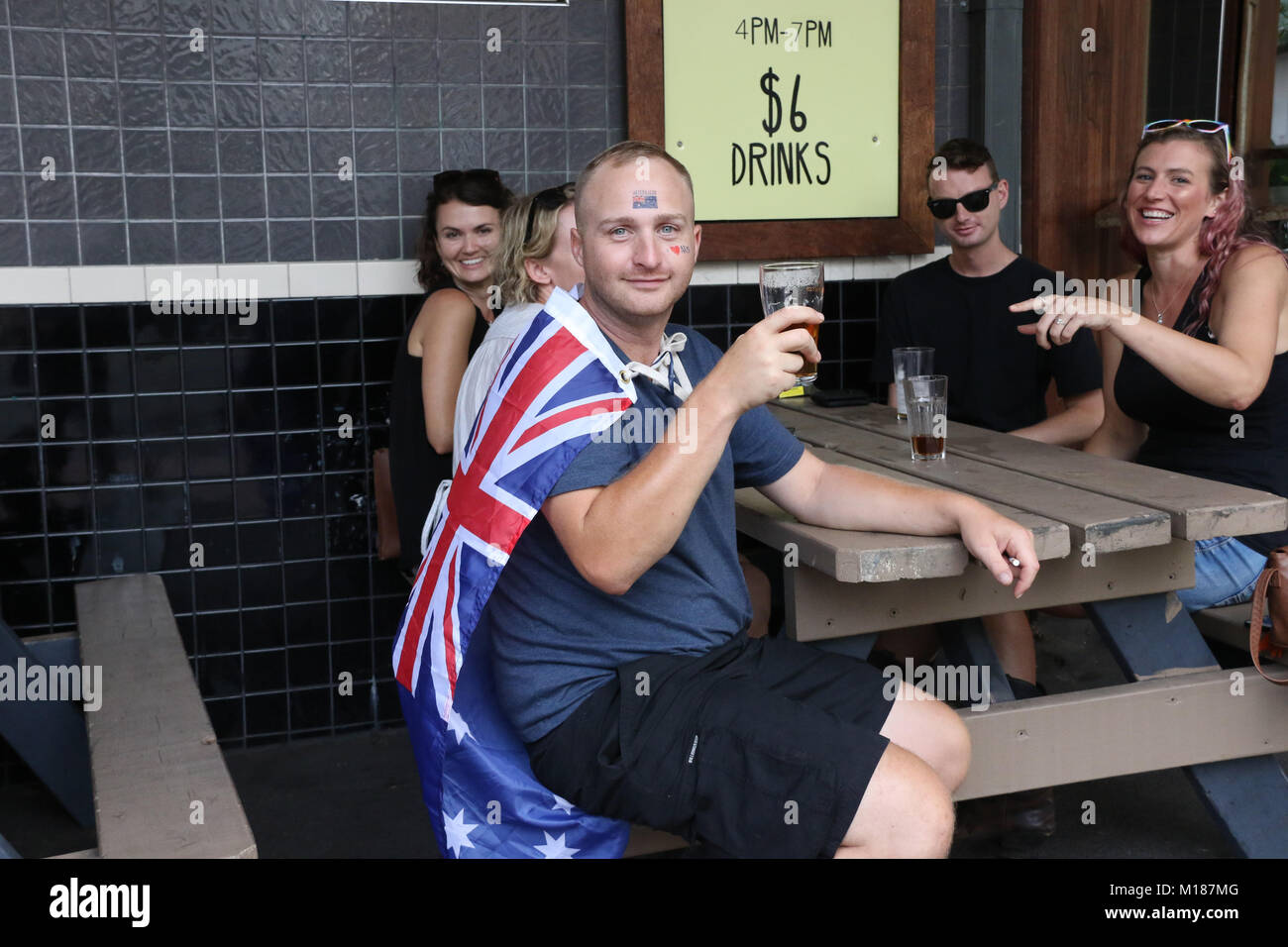 Un uomo celebra con i vostri amici in Australia giorno drappeggiati nella bandiera australiana al pub su Broadway Sydney. Foto Stock