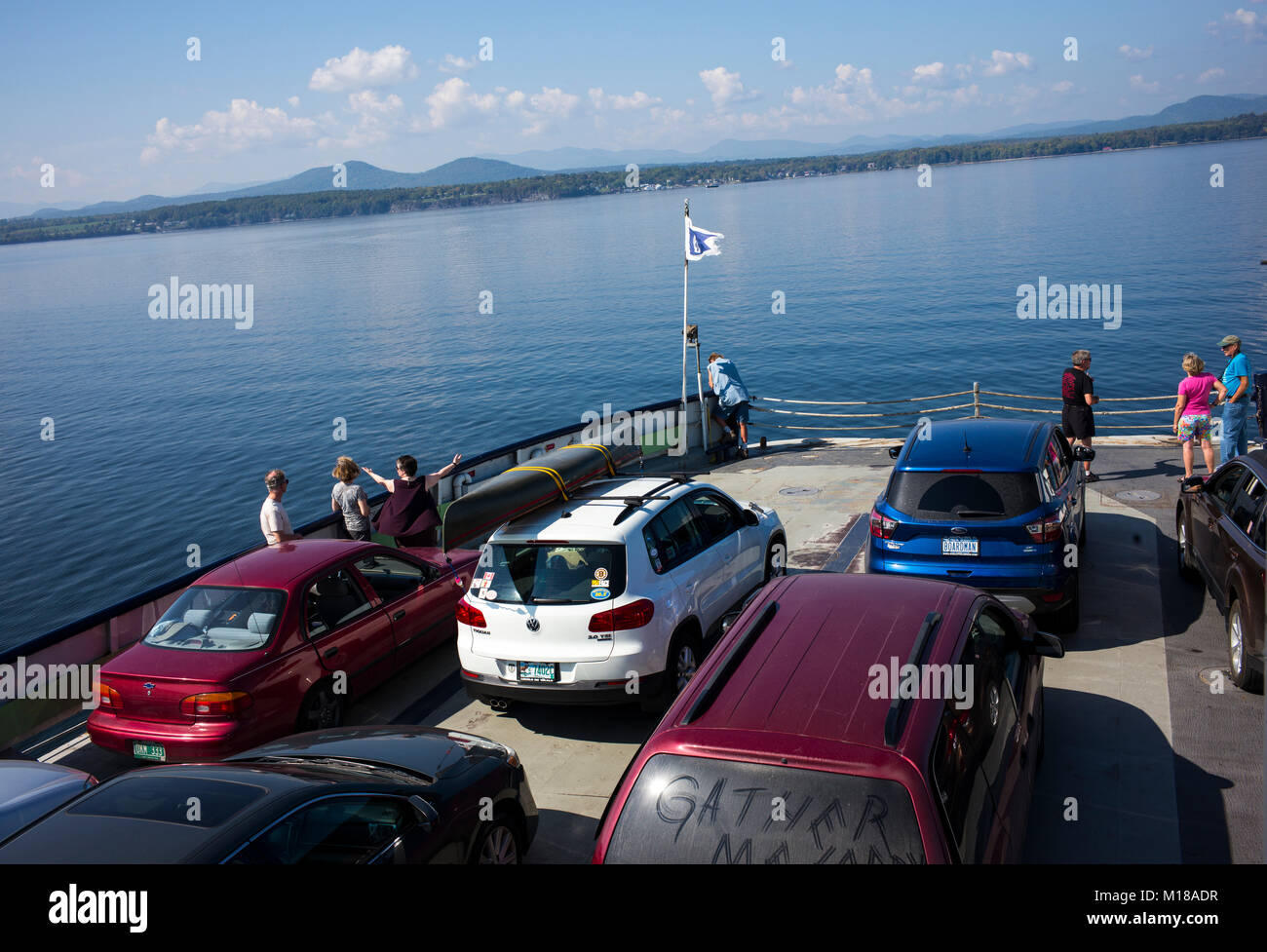 Traghetto per auto passeggeri stare vicino a prua mentre attraversano il lago Champlain da Charlotte, Vermont in direzione ovest di Essex, New York. Lake Champlain si estende oltre 100 miglia a sud dal confine canadese. Foto Stock