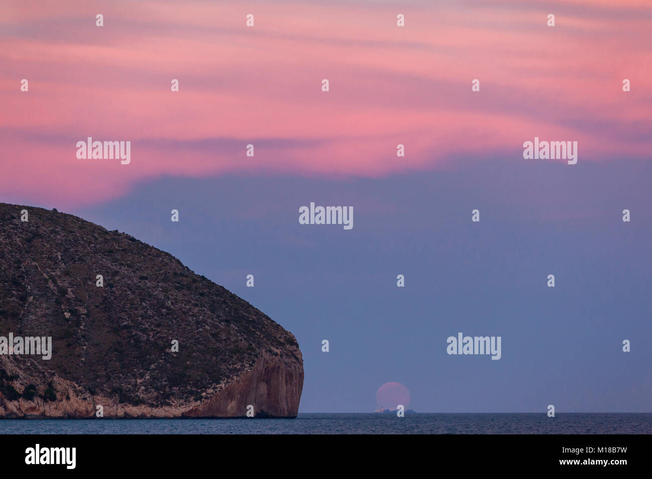 Tramonto con il sorgere della luna a Cap d'Or di Teulada-Moraira, Alicante, Spagna Foto Stock