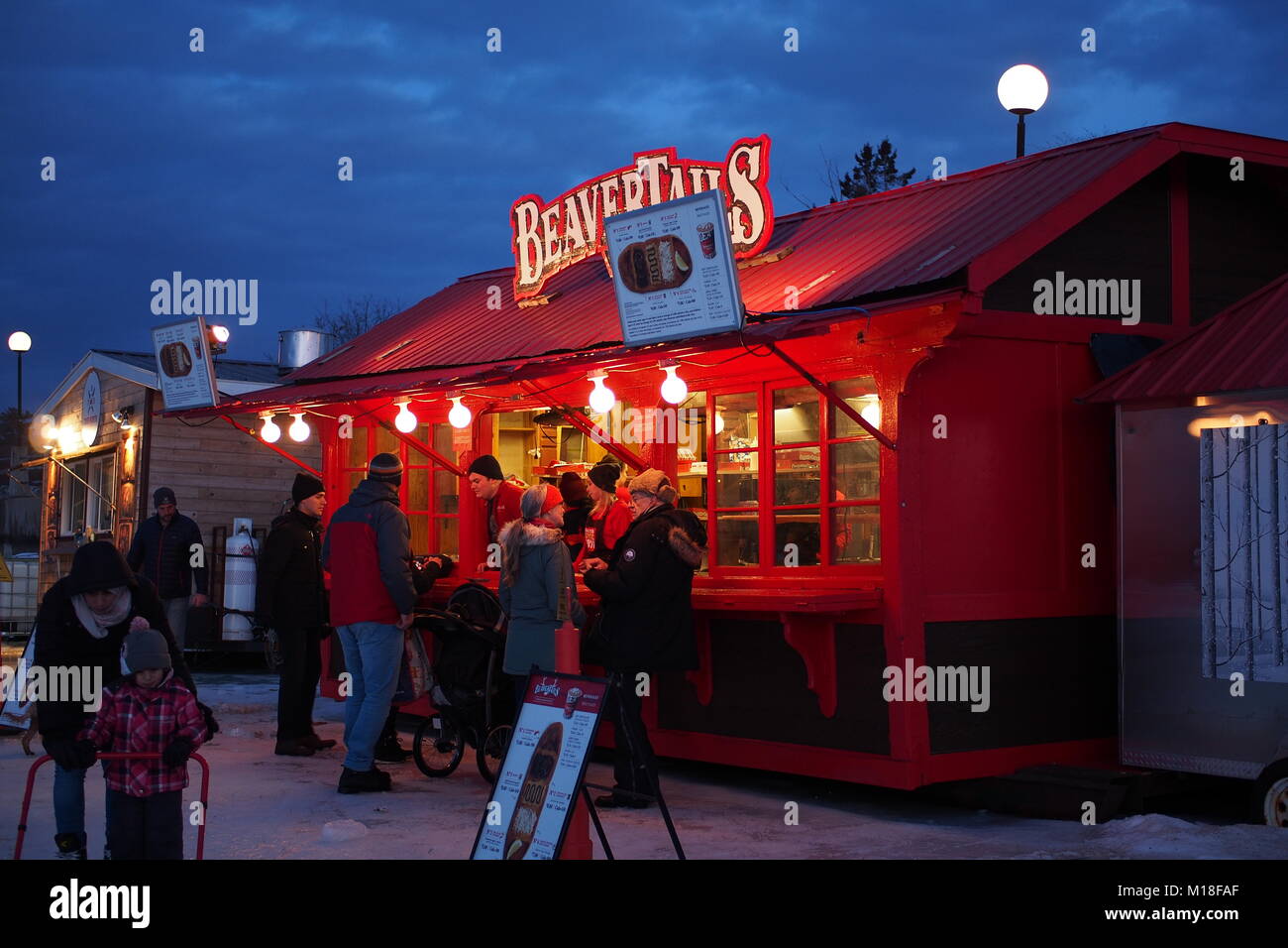 I clienti linea fino a coda di castoro kiosk presso l'estremità meridionale di Dow congelata del lago, Rideau Canal, Ottawa, Ontario, Canada. Foto Stock