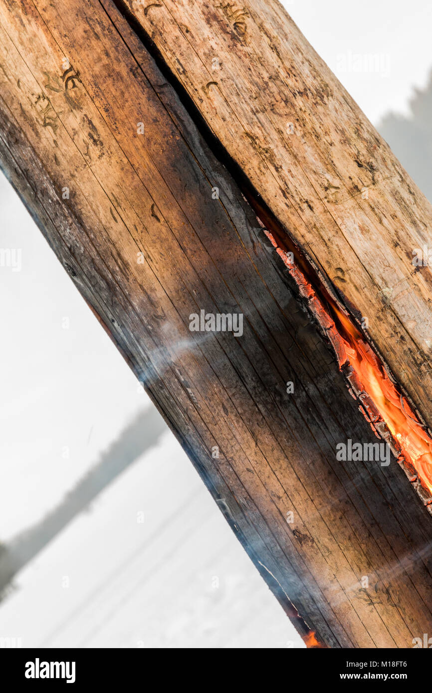 Torcia svedese fuoco stub sulla piastra per il riposo e per il riscaldamento in inverno in montagna. Foto Stock