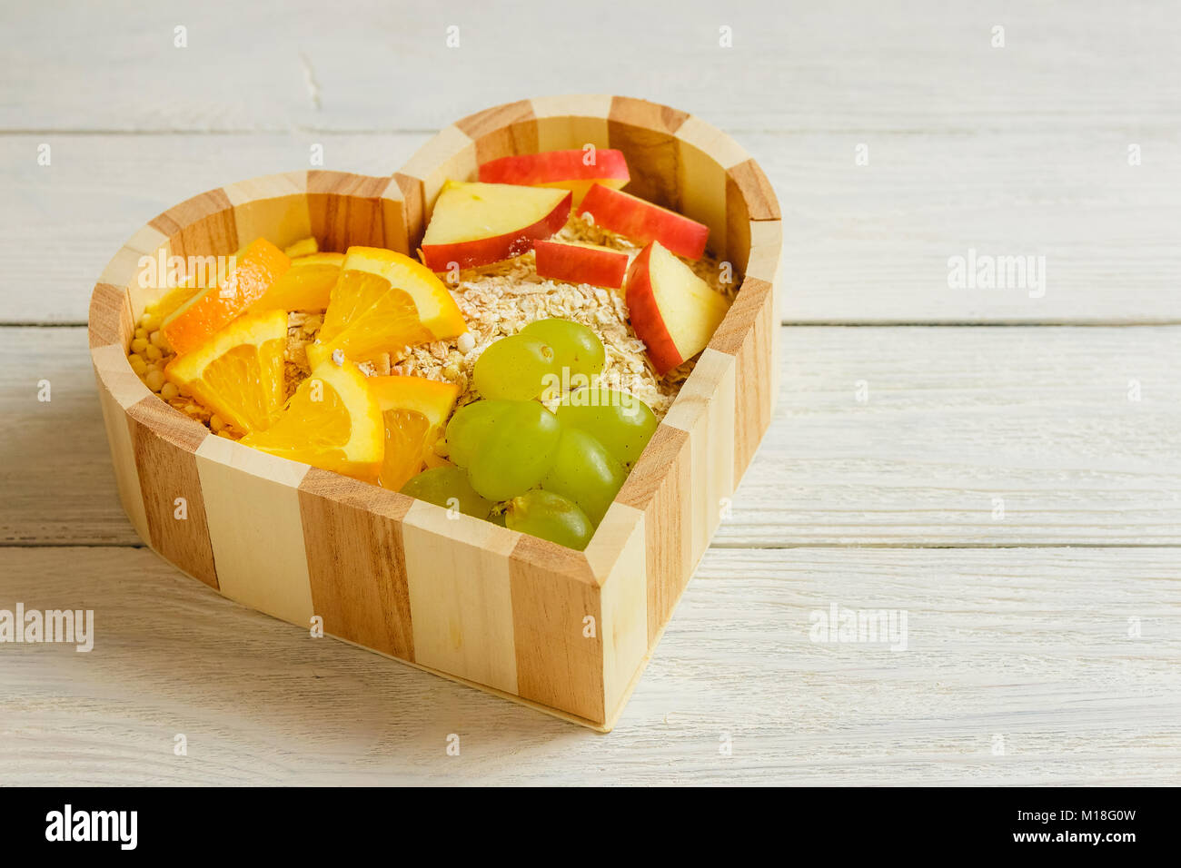 Frutti cuore su sfondo di legno. Cibo sano concetto. Foto Stock