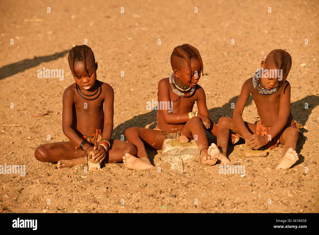 Himbamädchen macinare il grano,Kunene,Kaokoveld,Namibia Foto Stock