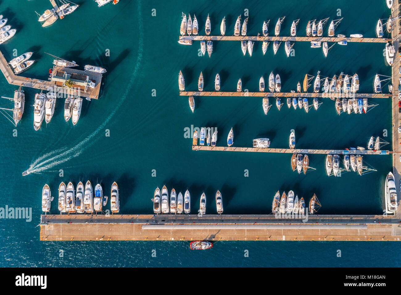 Vista aerea di incredibili imbarcazioni al tramonto. Paesaggio minimalista con barche e mare di Marina Bay. Vista dall'alto da fuco del porticciolo di yacht, un motoscafo Foto Stock