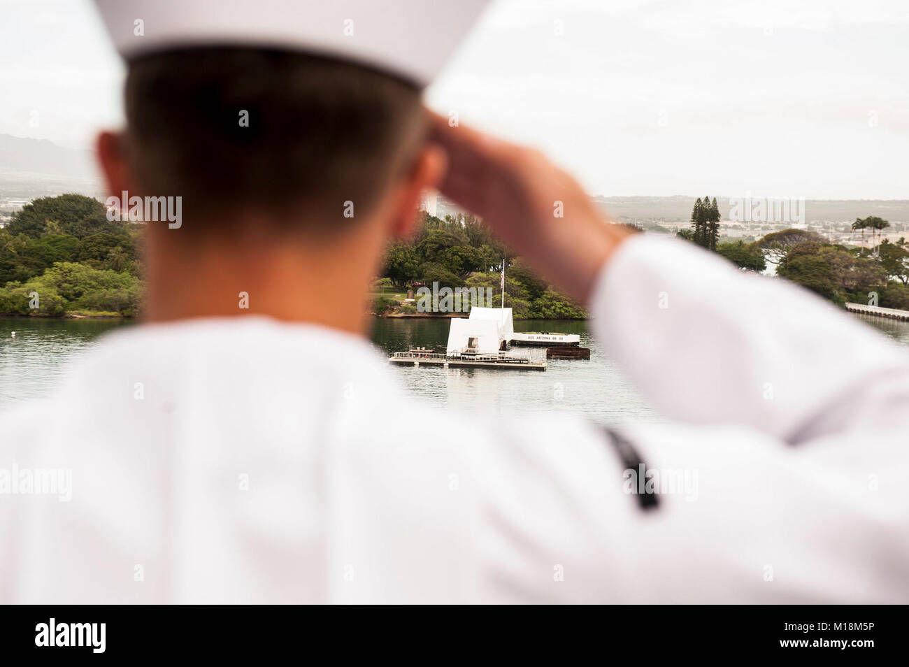 BASE COMUNE DI PEARL HARBOR-HICKAM (GEN. 25, 2018) un marinaio a bordo dell'assalto anfibio nave USS America (LHA 6) rende onore a USS Arizona Memorial come la nave parte Base comune Harbor-Hickam perla dopo una porta programmata visita. America, parte dell'America anfibio gruppo pronto, con avviato xv Marine Expeditionary Unit, è di ritorno da 7 mesi di distribuzione per gli Stati Uniti 3a, 5 e 7 settori della flotta delle operazioni. (U.S. Navy Foto Stock