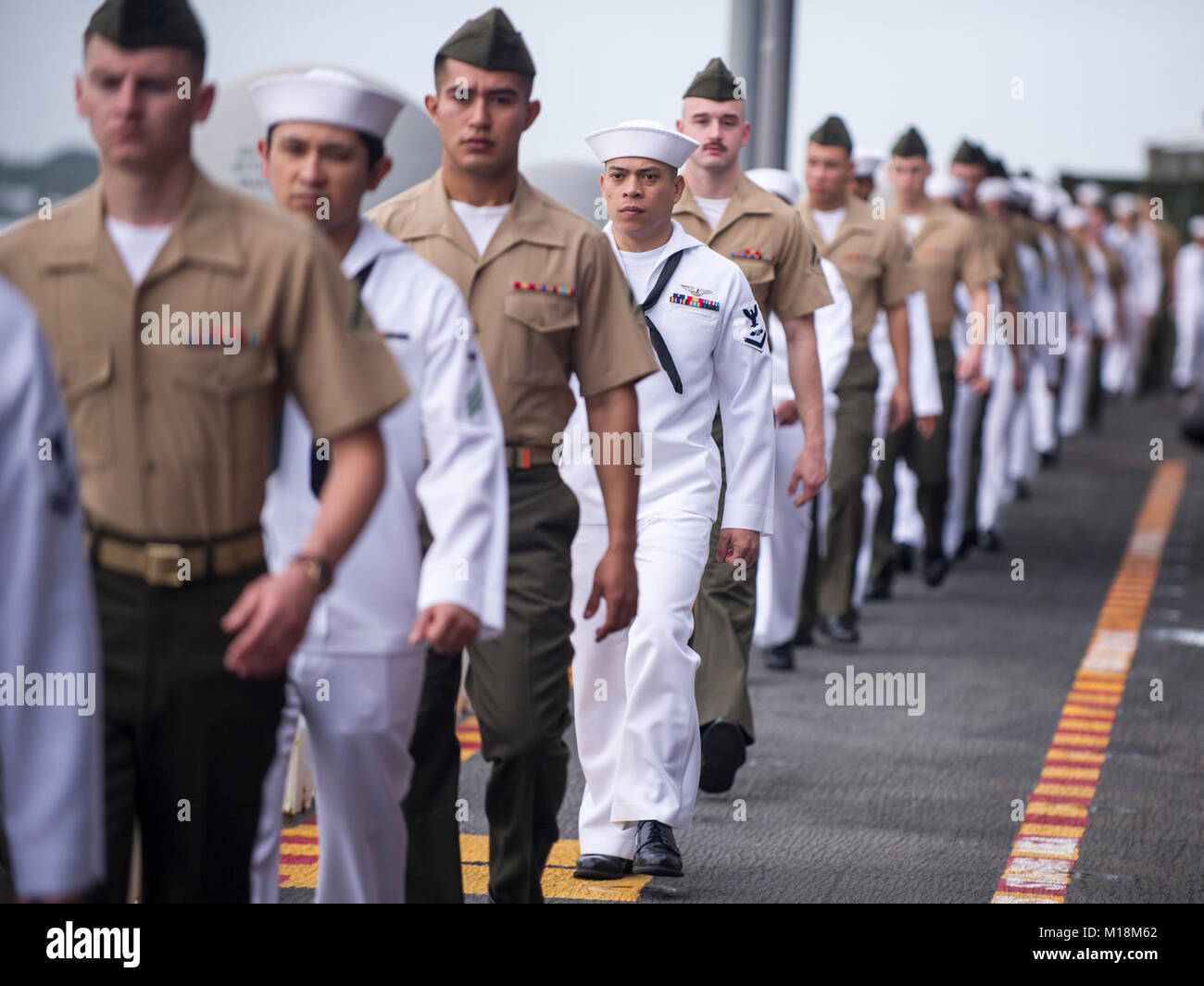 BASE COMUNE DI PEARL HARBOR-HICKAM (GEN. 25, 2018) Marinai e Marines a bordo dell'assalto anfibio nave USS America (LHA 6) preparare all'uomo le rotaie come la nave parte Base comune Harbor-Hickam perla dopo una porta programmata visita. America, parte dell'America anfibio gruppo pronto, con avviato xv Marine Expeditionary Unit, è di ritorno da 7 mesi di distribuzione per gli Stati Uniti 3a, 5 e 7 settori della flotta delle operazioni. (U.S. Navy Foto Stock