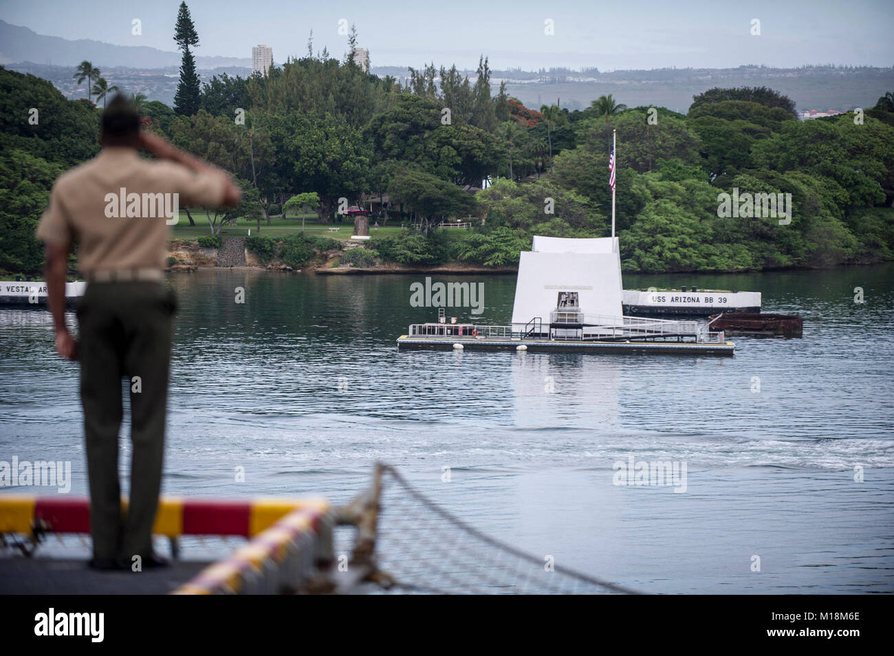 BASE COMUNE DI PEARL HARBOR-HICKAM (GEN. 25, 2018) di un Marine assegnato al XV Marine Expeditionary Unit a bordo dell'assalto anfibio nave USS America (LHA 6) saluta la USS Arizona Memorial mentre manning le rotaie come la nave parte Base comune Harbor-Hickam perla dopo una porta programmata visita. America, parte dell'America anfibio gruppo pronto, con avviato xv Marine Expeditionary Unit, è di ritorno da 7 mesi di distribuzione per gli Stati Uniti 3a, 5 e 7 settori della flotta delle operazioni. (U.S. Navy Foto Stock