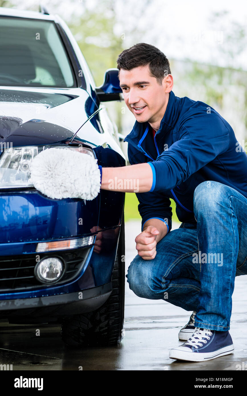 Orgoglioso proprietario di auto pulizia dei proiettori Foto Stock