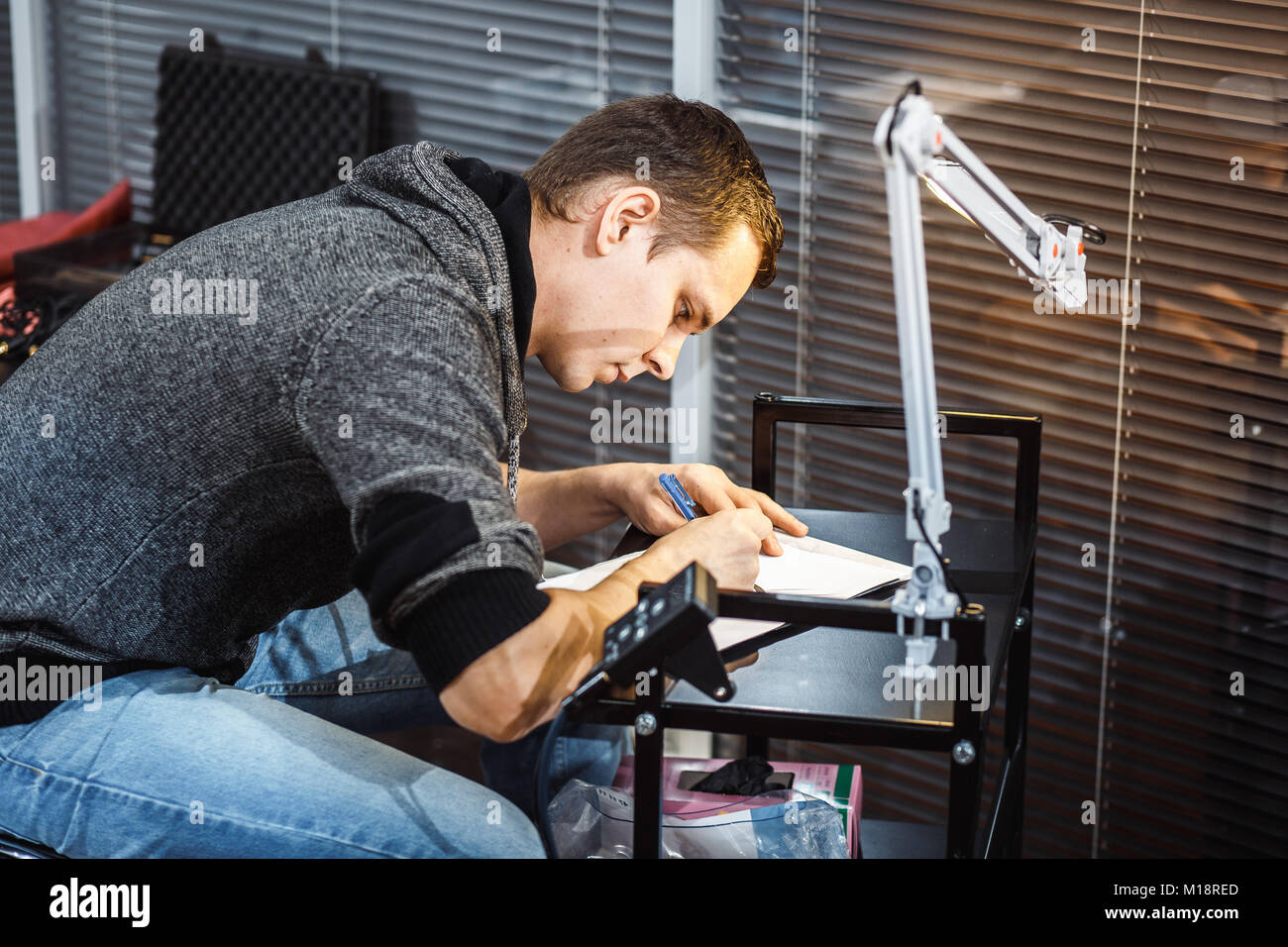Creazione di un tatuaggio di close-up. L'artista cerchiato la penna con un tatuaggio schizzo Foto Stock