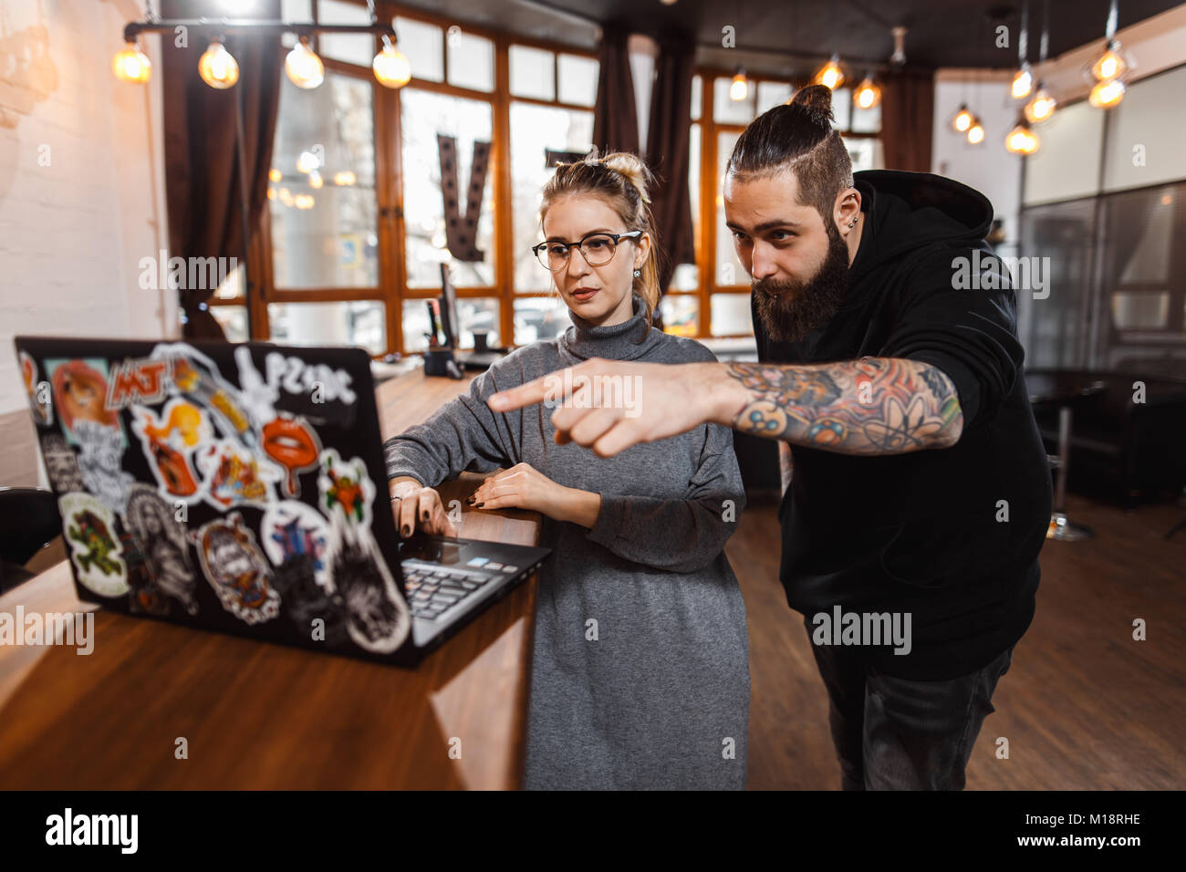 L uomo e la donna a discutere su digital portatile in ufficio creativo Foto Stock