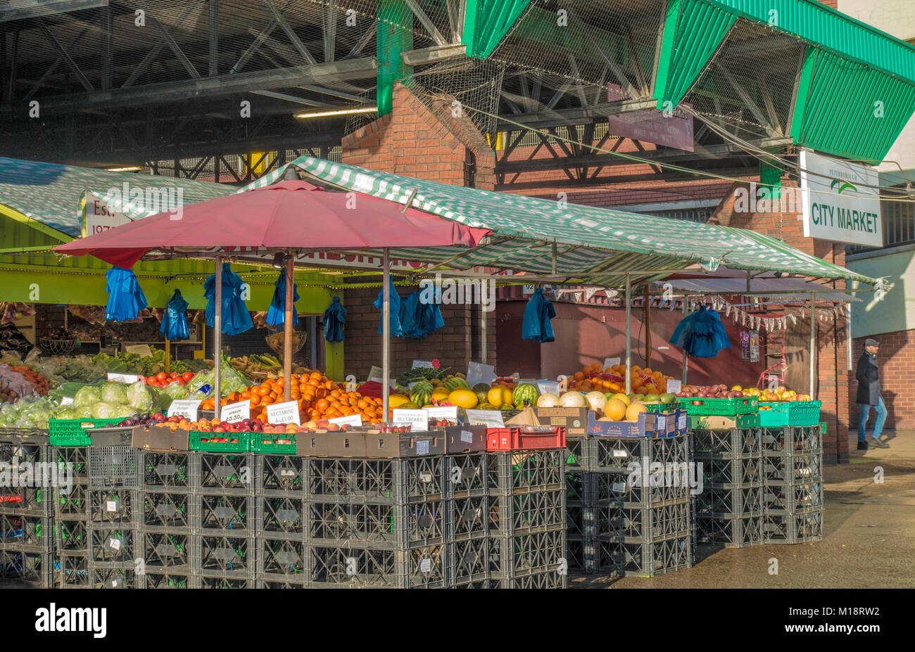 Frutta fresca e verdura stallo, con appeso sacchi da asporto, nel mercato di Peterborough city centre, Cambridgeshire, Inghilterra, Regno Unito. Foto Stock