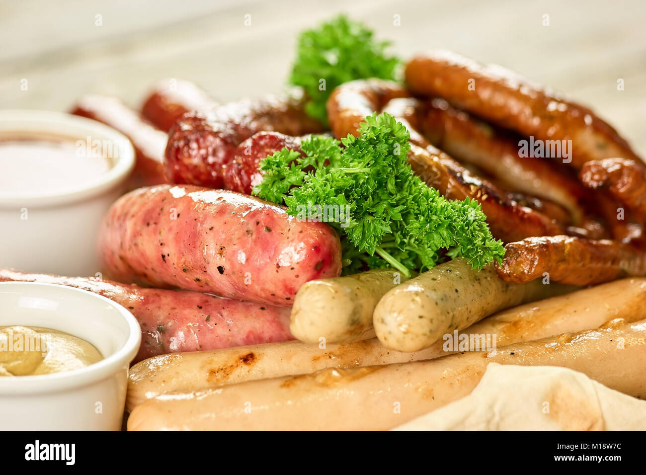 Piatto con sei tipi di salsicce sul piatto di legno, primo piano. Foto Stock