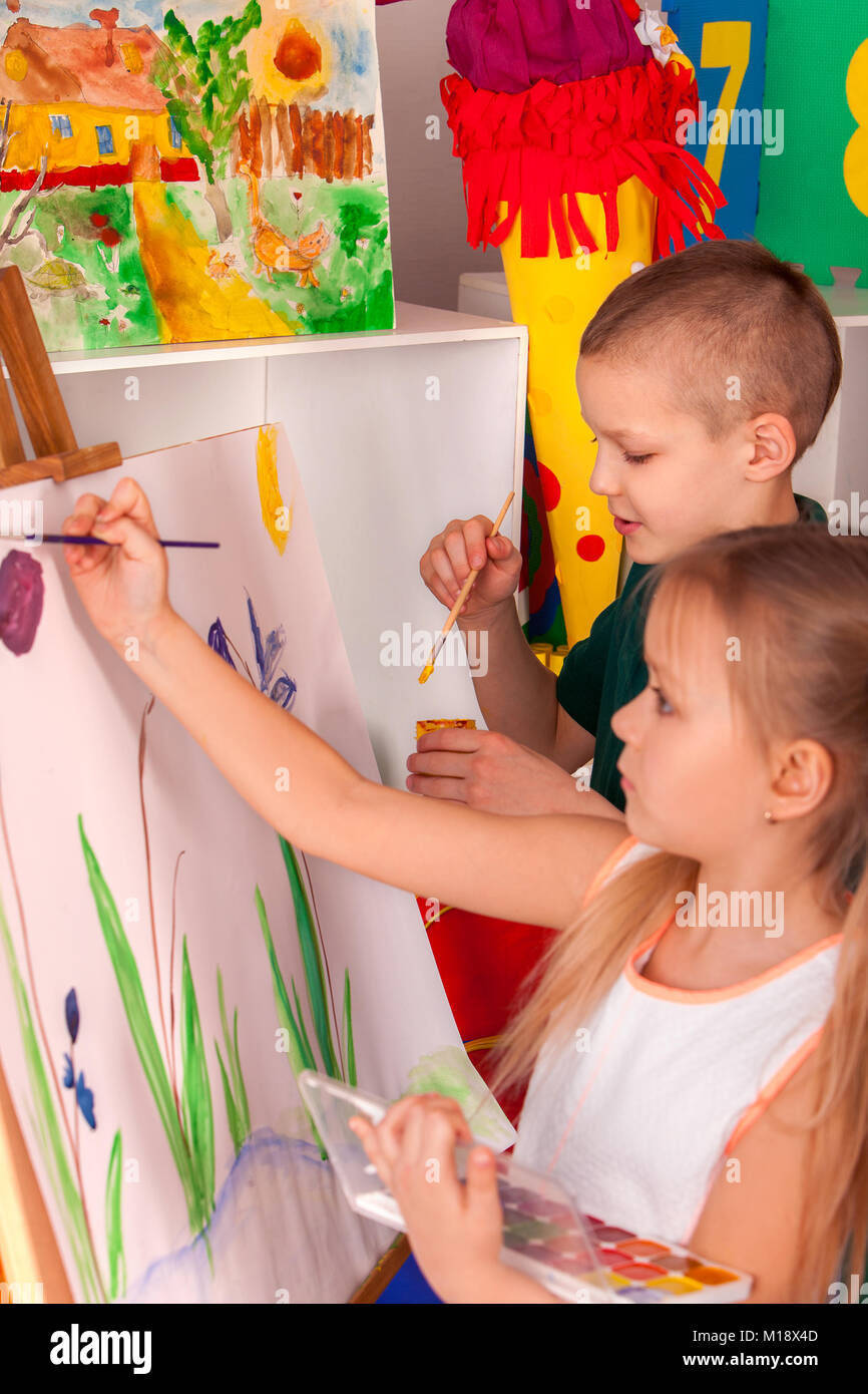 Bambini pittura dito sul cavalletto. Un gruppo di ragazzi con