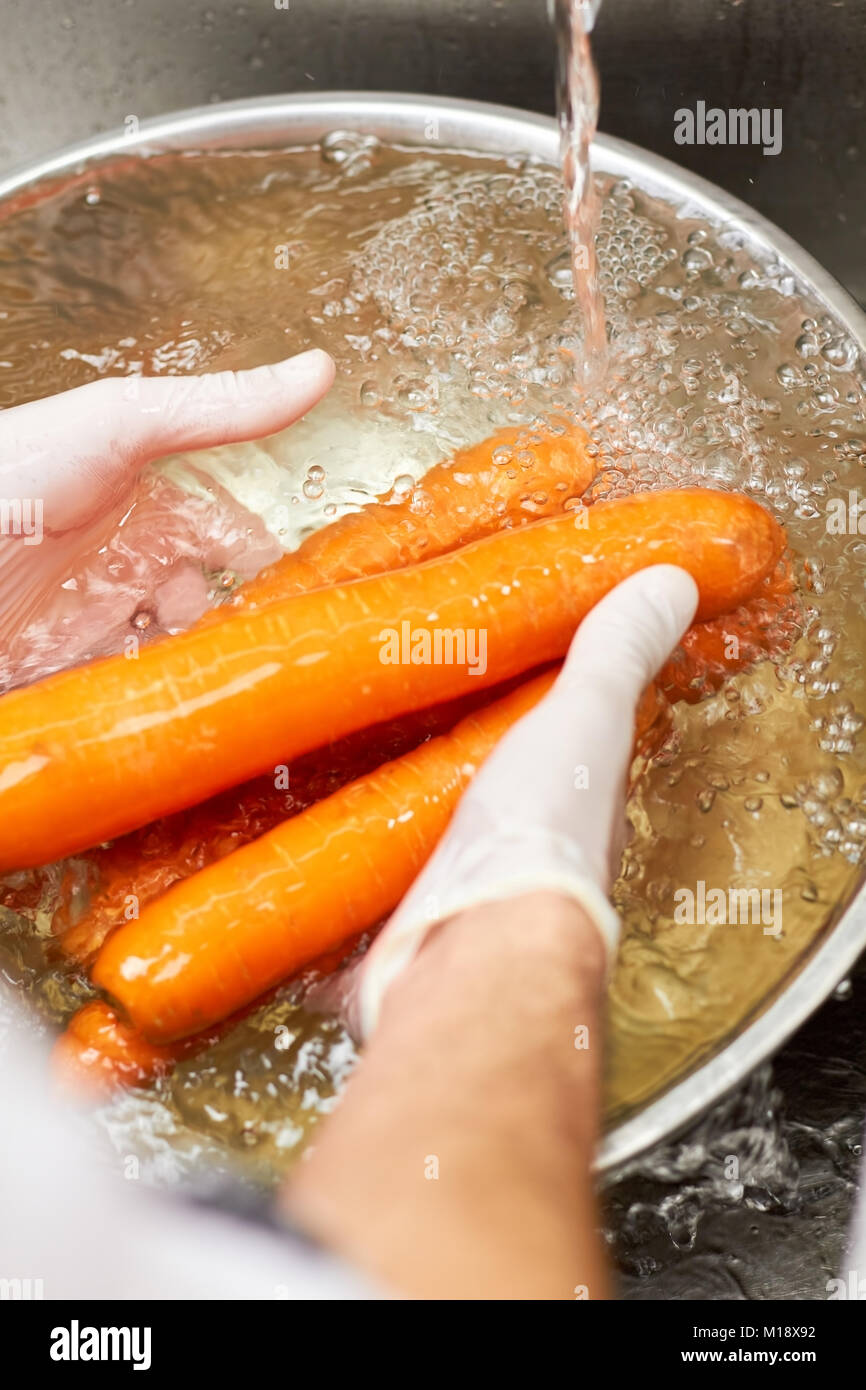 Diverse le carote lavaggio sotto acqua corrente. Foto Stock