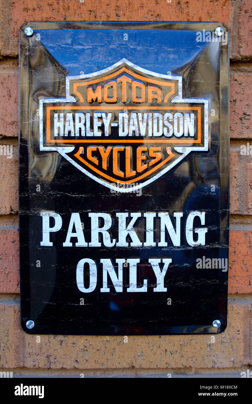 Effettuare lo spoofing di avviso su una piastra smaltata montato su di un muro di mattoni la lettura Harley Davidson Moto parcheggio solo Foto Stock