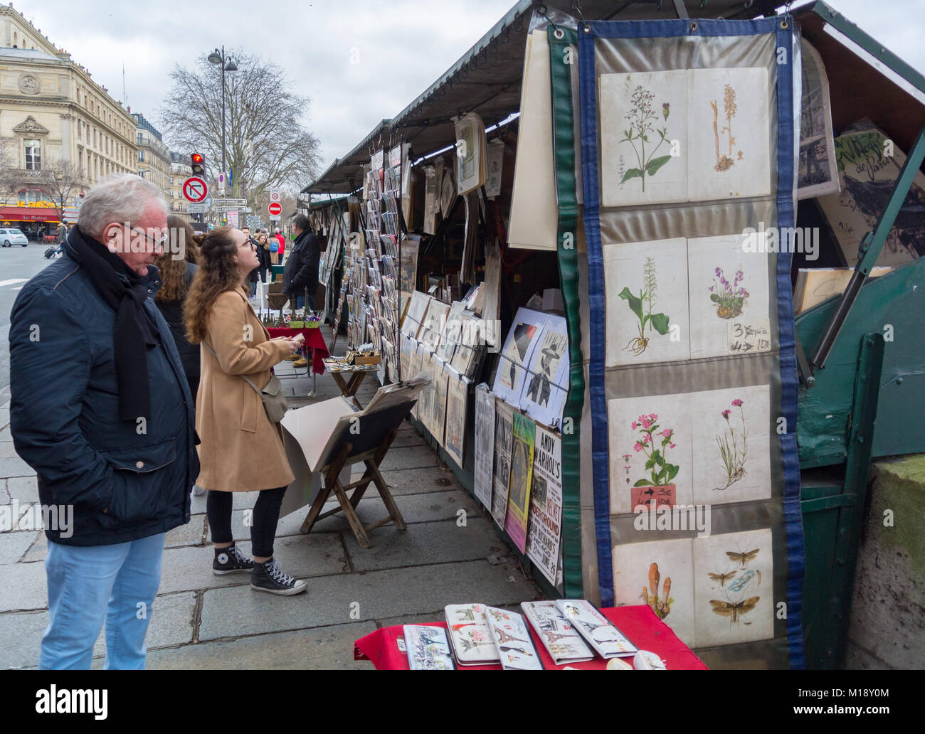Turisti caucasico guardando vecchi manifesti a un cavalletto lungo la senna riiver, Parigi, Francia Foto Stock