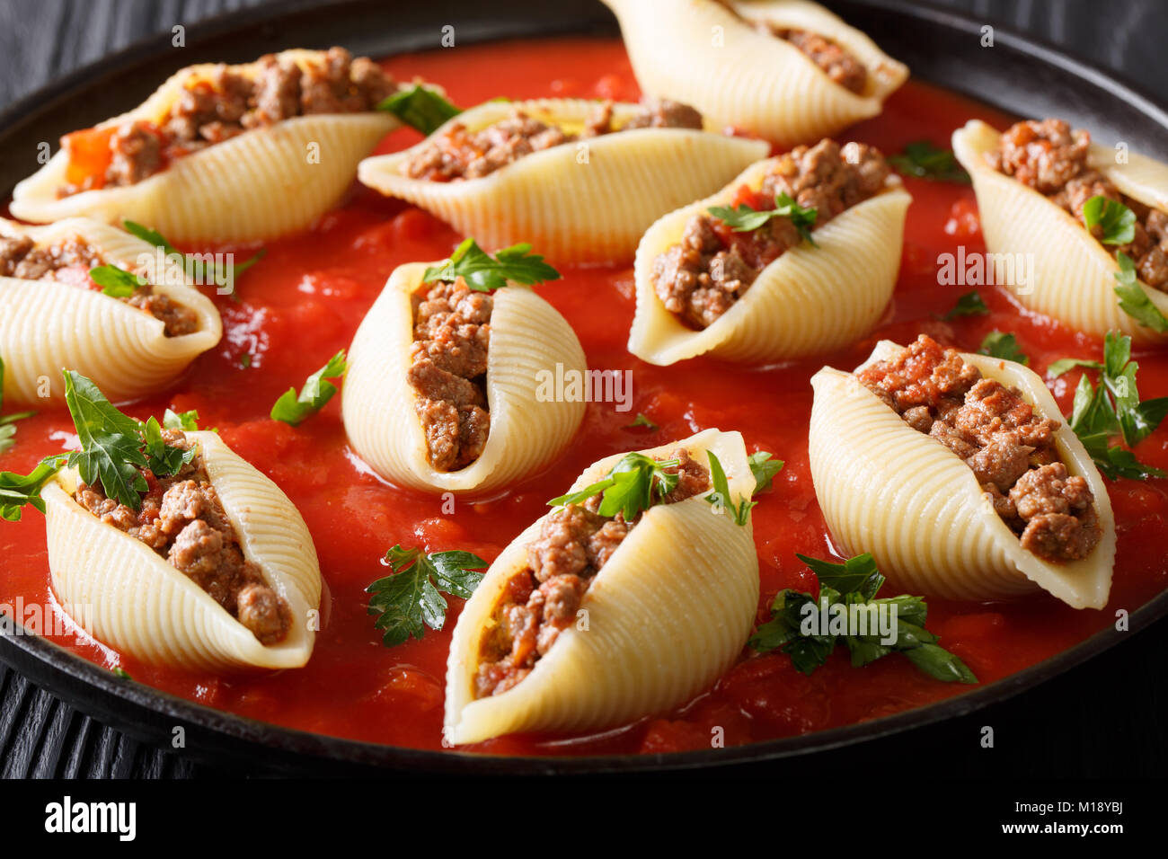 Guscio di pasta conchiglioni farcite con carne di manzo con salsa marinara close-up sulla piastra sulla tavola orizzontale. Foto Stock