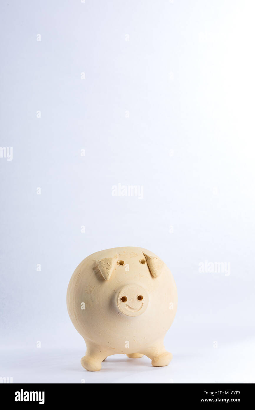 Maialino fatti di argilla gialla per salvare i risparmi sorridente, è isolato su sfondo bianco. Spazio libero per il testo Foto Stock