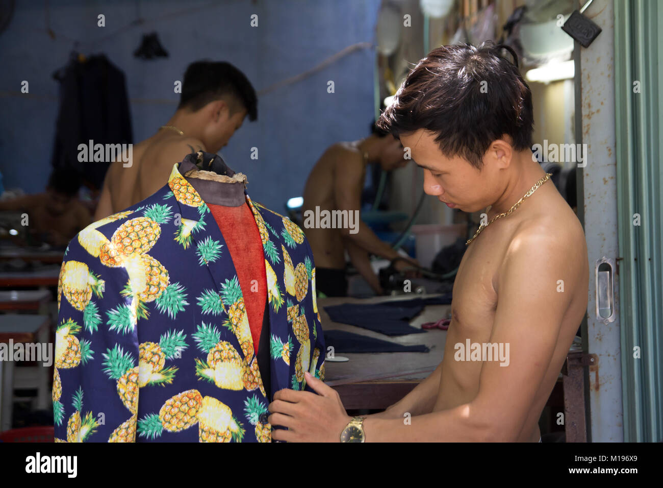 Uomo su misura rendendo i vestiti in laboratorio tessile in Vietnam Foto Stock