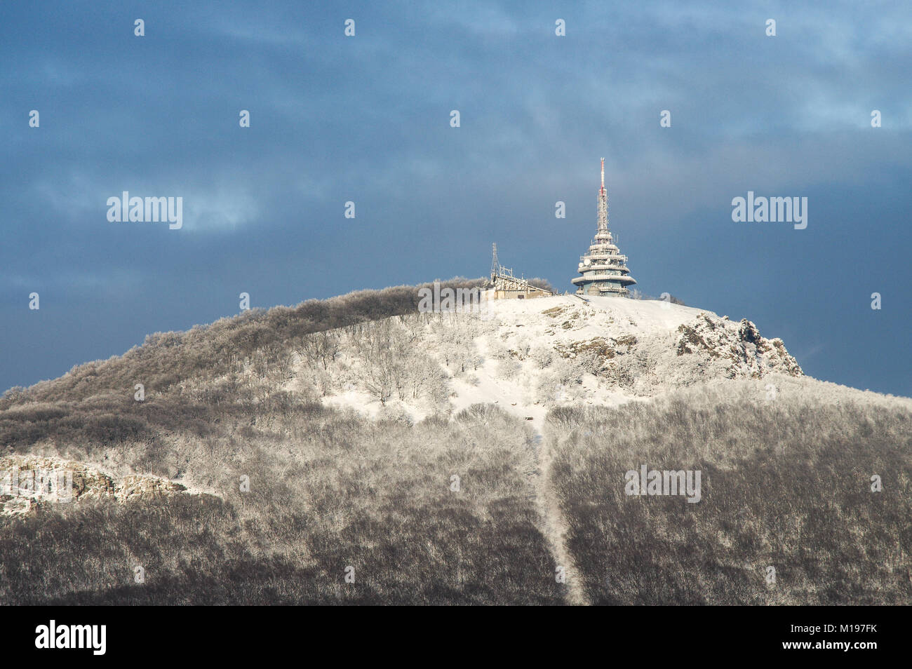 Coperte di neve Zobor collina sopra la città slovacca Nitra su una luminosa e soleggiata giornata invernale Foto Stock